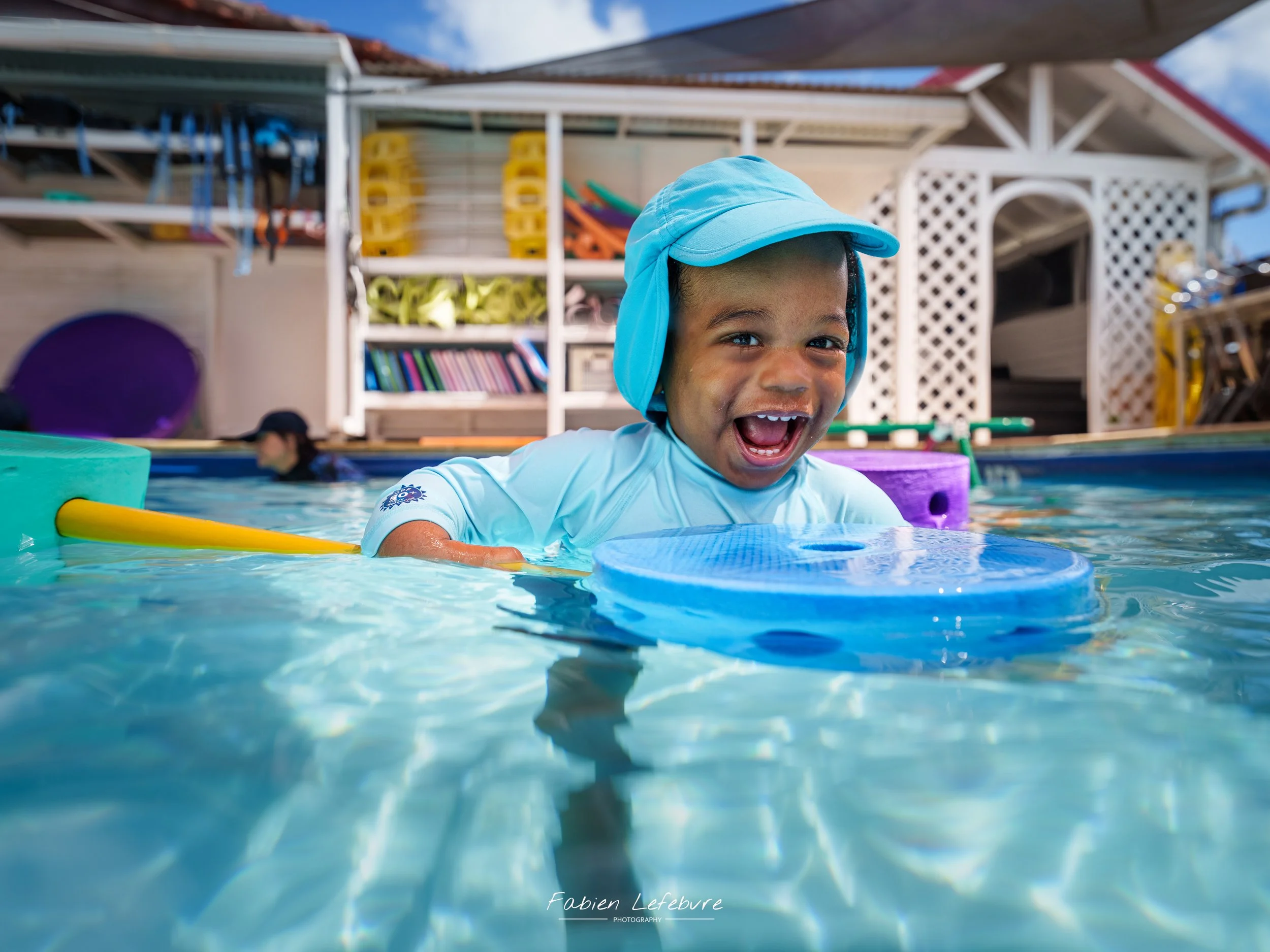 Bébé qui nage dans une piscine en séance bébé nageur en Martinique au fil à eau