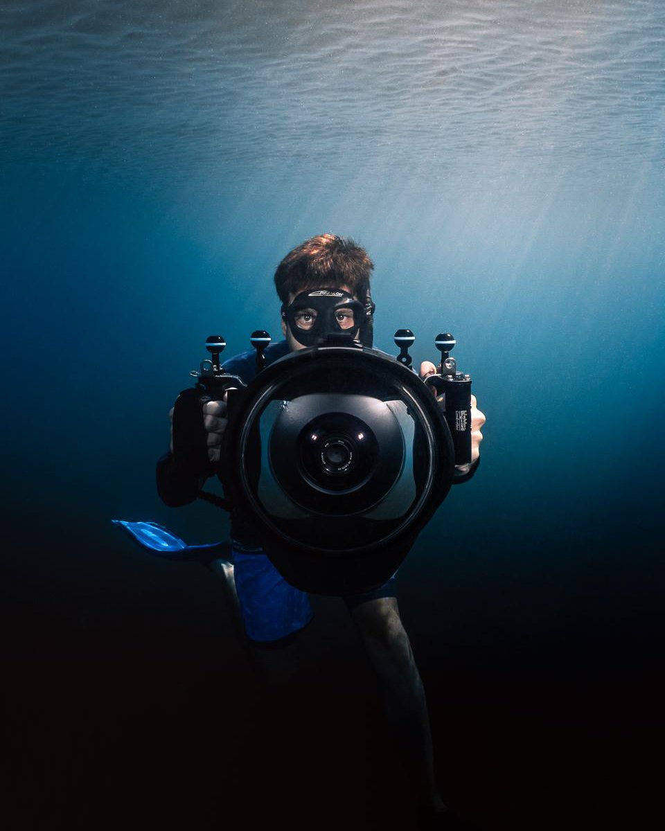 Fabien Lefebvre sous l’eau face à l’objectif, tenant un caisson étanche nauticam en martinique