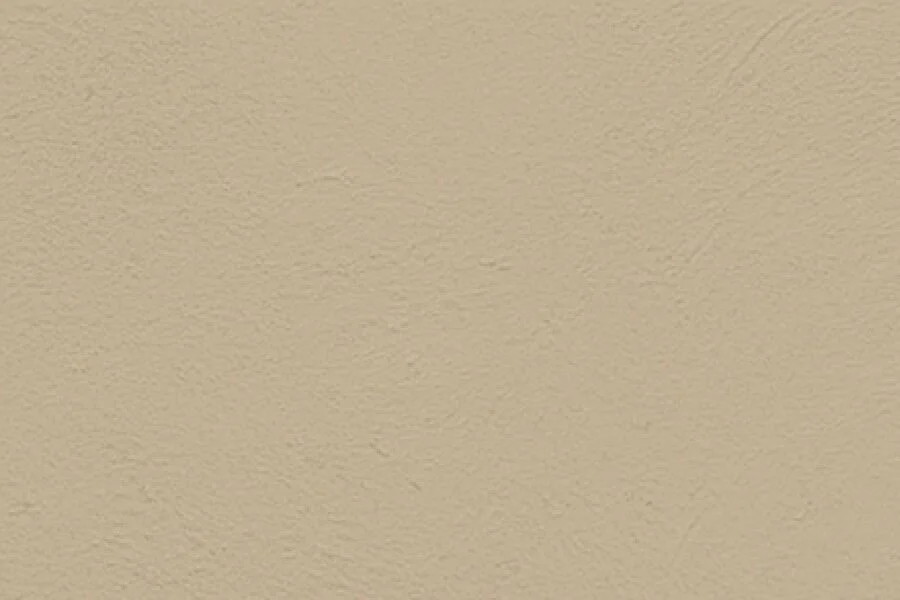 A beige textured wall with a small shadow at the upper left corner.