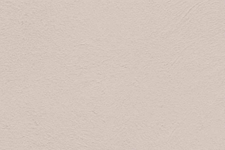 A close-up of a beige or light tan textured wall.