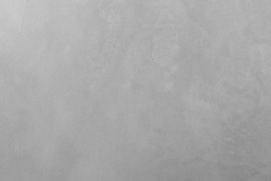 A blank, gray concrete wall with a subtle textured surface.
