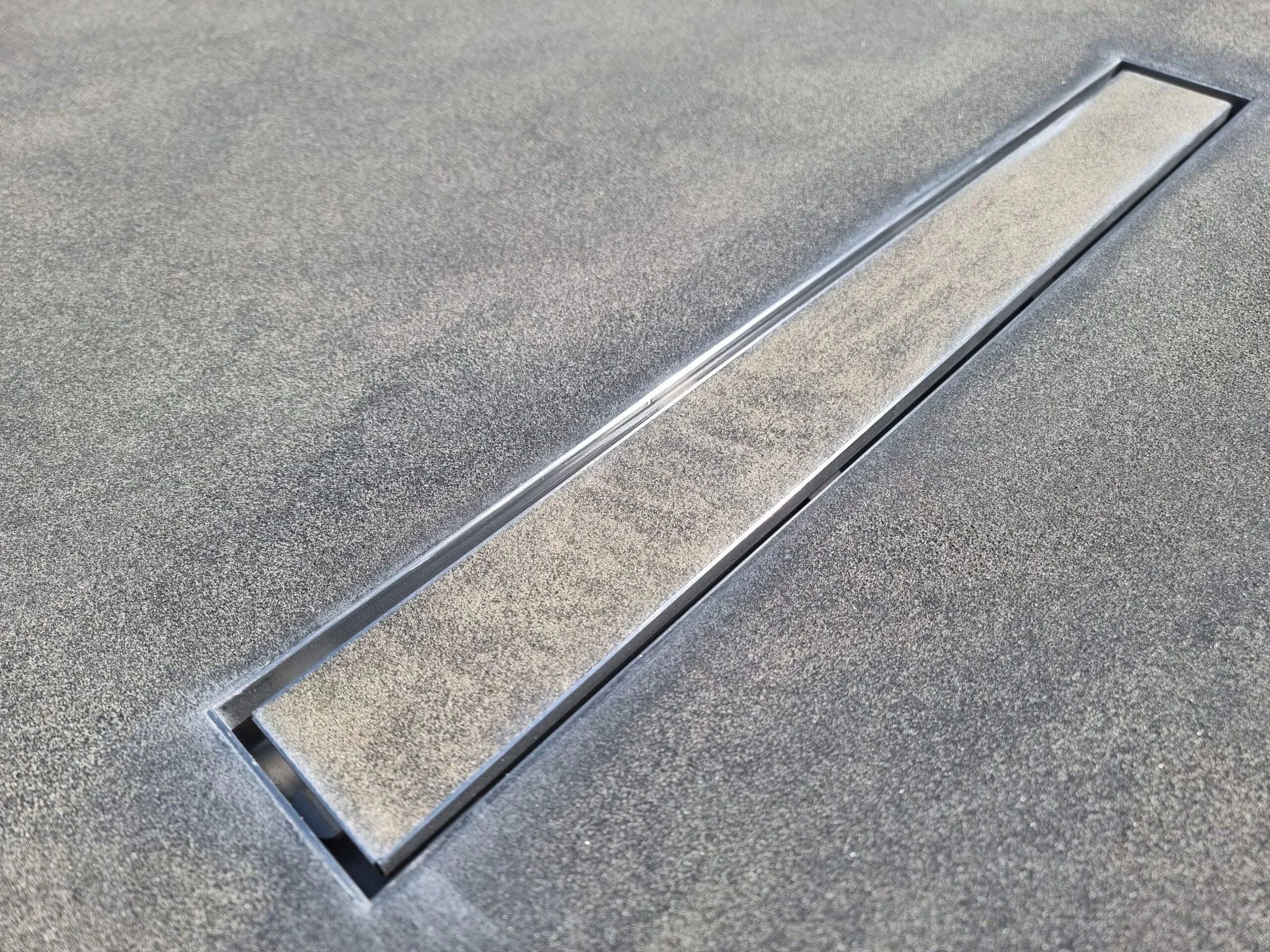 Close-up of a textured countertop with a built-in metallic slot or drainage channel.