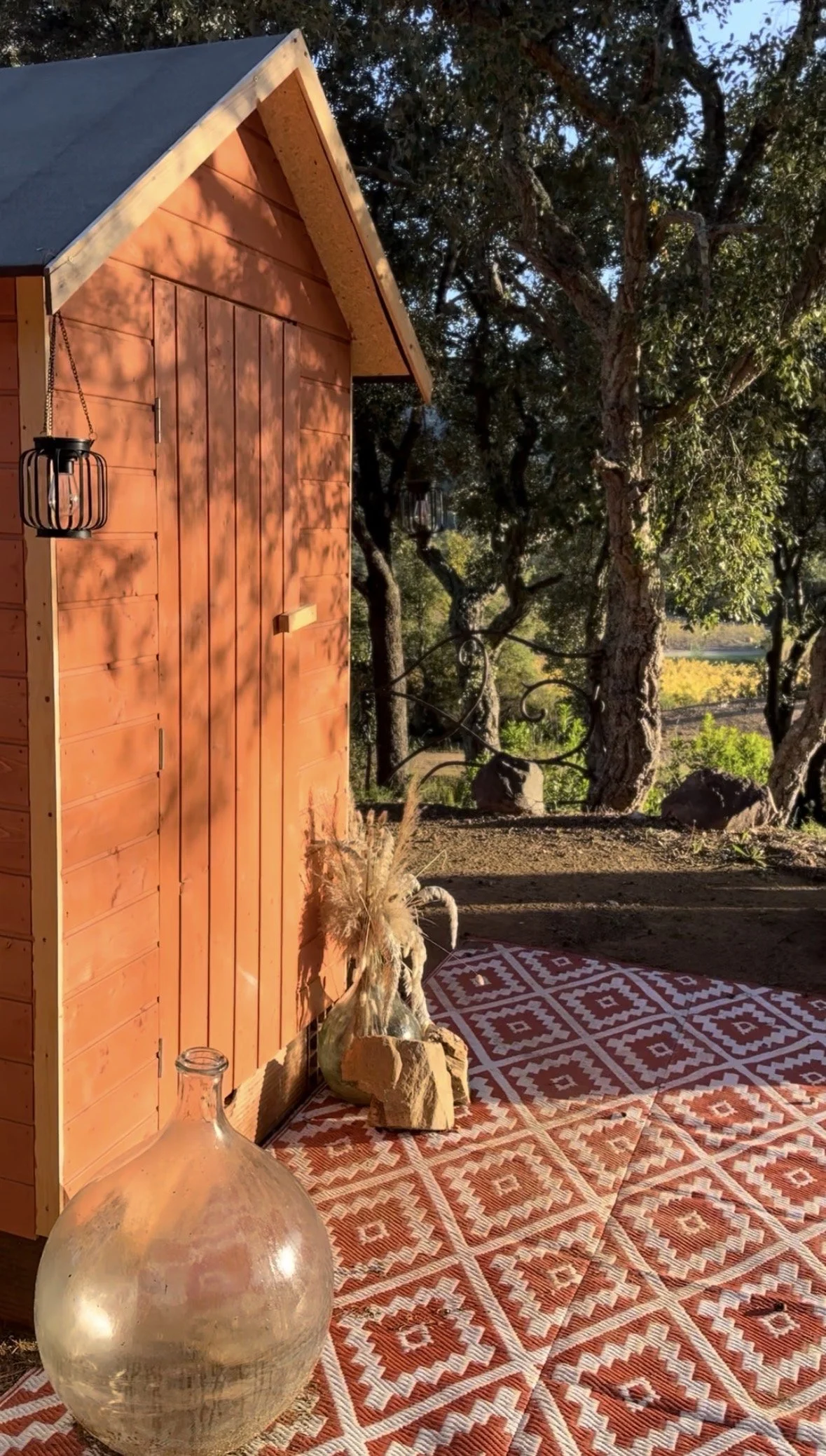 Cabanon de toilettes sèches en bois, niché sous les chênes, avec une décoration simple et naturelle qui s’inscrit harmonieusement dans l’environnement du lieu.