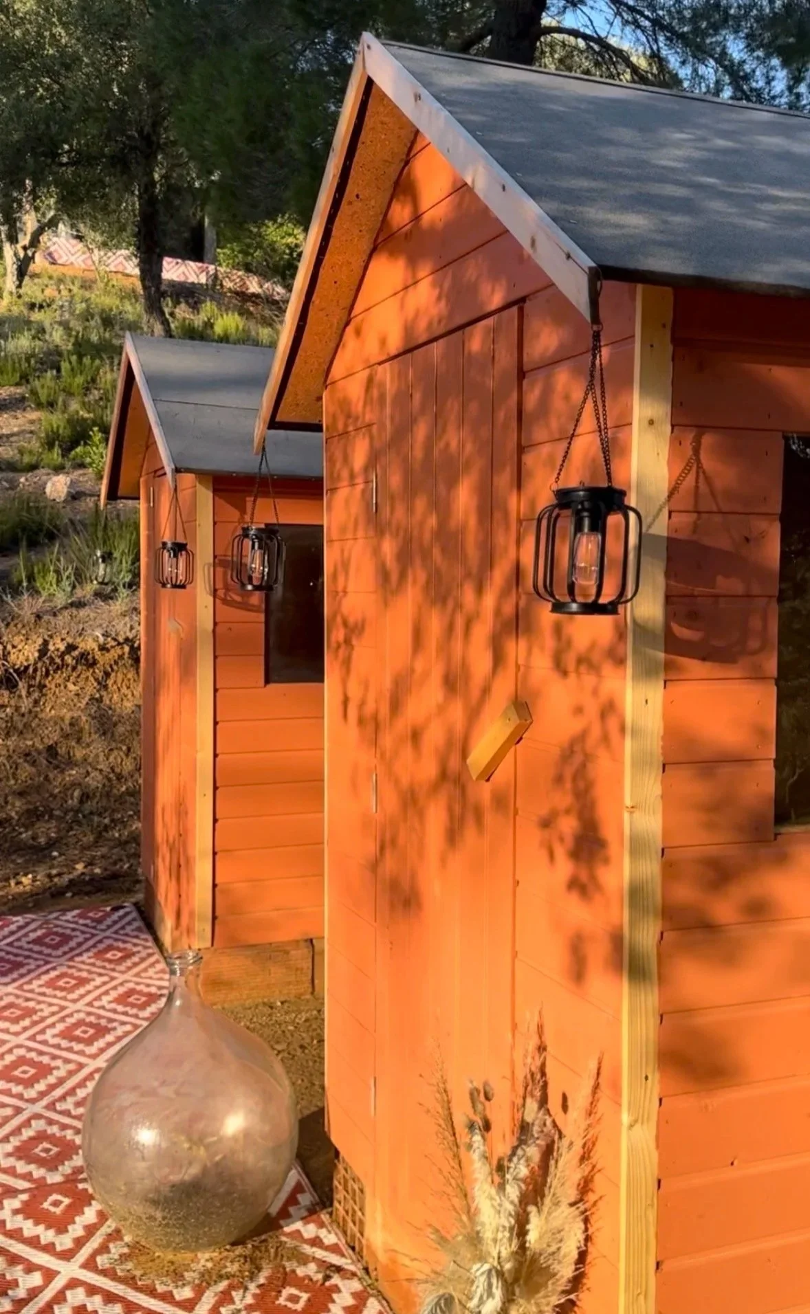 Cabanons en bois abritant des toilettes sèches écologiques, sur un lieu de retraite en pleine nature en Provence.