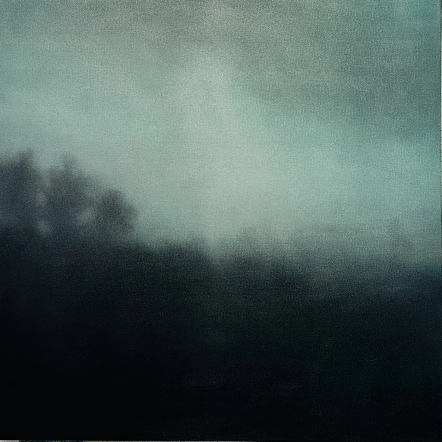 Atmospheric dark green painting  of foggy misty landscape with dark trees in the lower left corner.