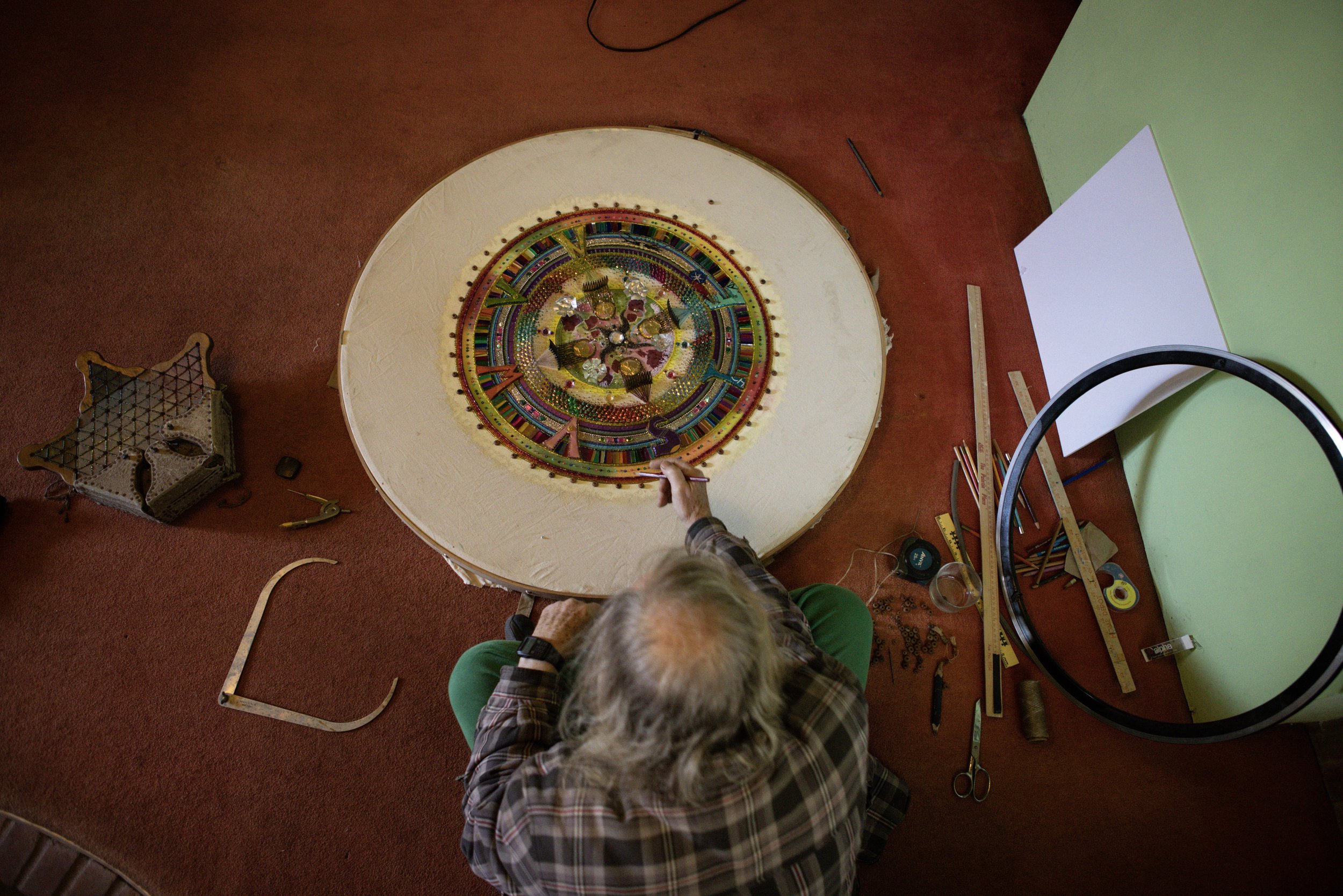 Talbot works on his art piece besides his tools and older art pieces in the living room.