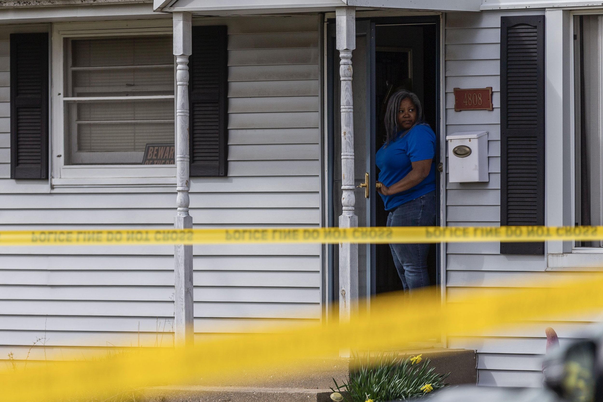 A resident looks out from the front door of a home Wednesday, March 27, 2024, as police investigate a spree of violence that unfolded in Rockford leaving 4 dead and 5 harmed.