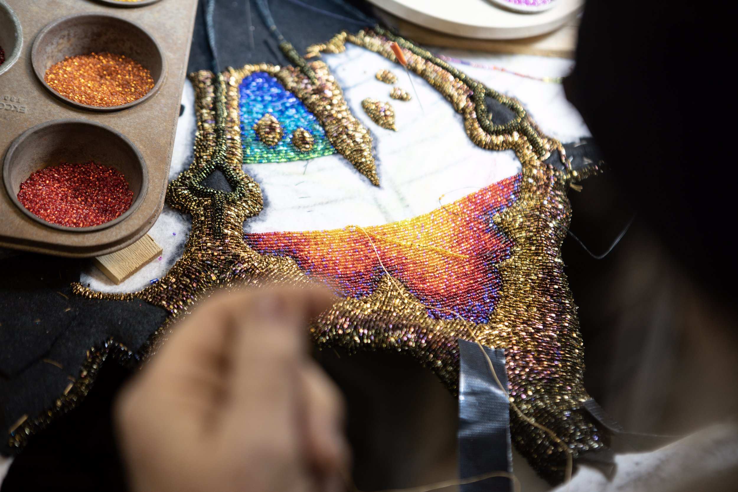 Talbot works on his latest project, a hand beaded tapestry of a rainbow moth. TA tapestry such as this can take hundreds of hours of work to complete one.