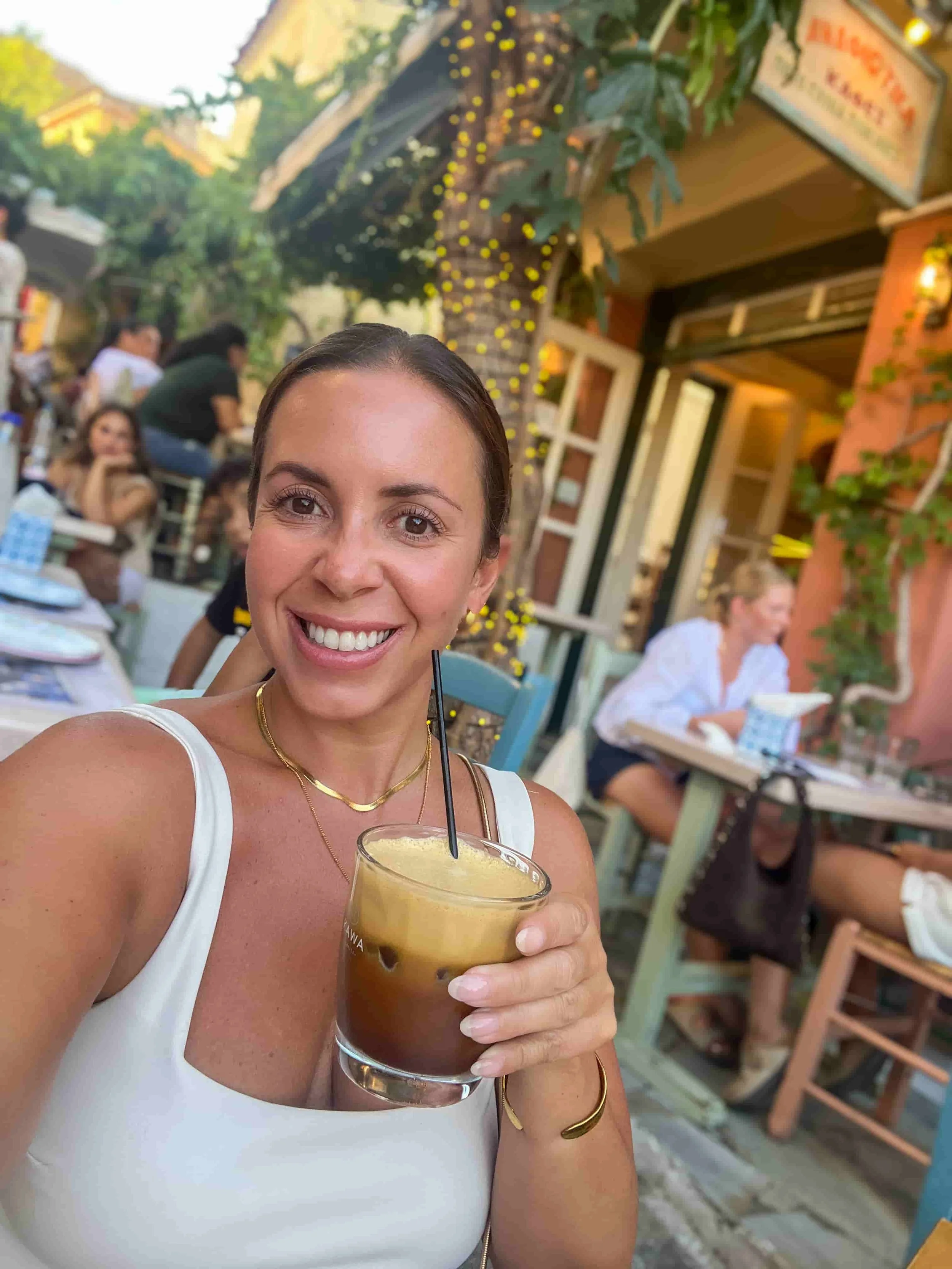 Solo traveler sitting at a table overlooking cobblestone street in Plaka