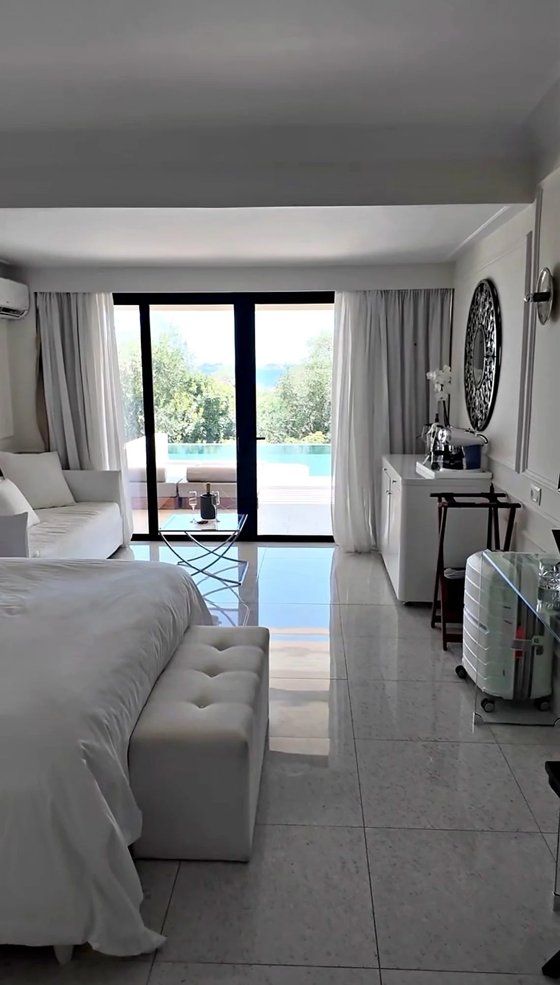 A Swim Up Junior Bungalow Suite at Grecotel Corfu Imperial, Corfu, from the bed through the glass doors to the private pool