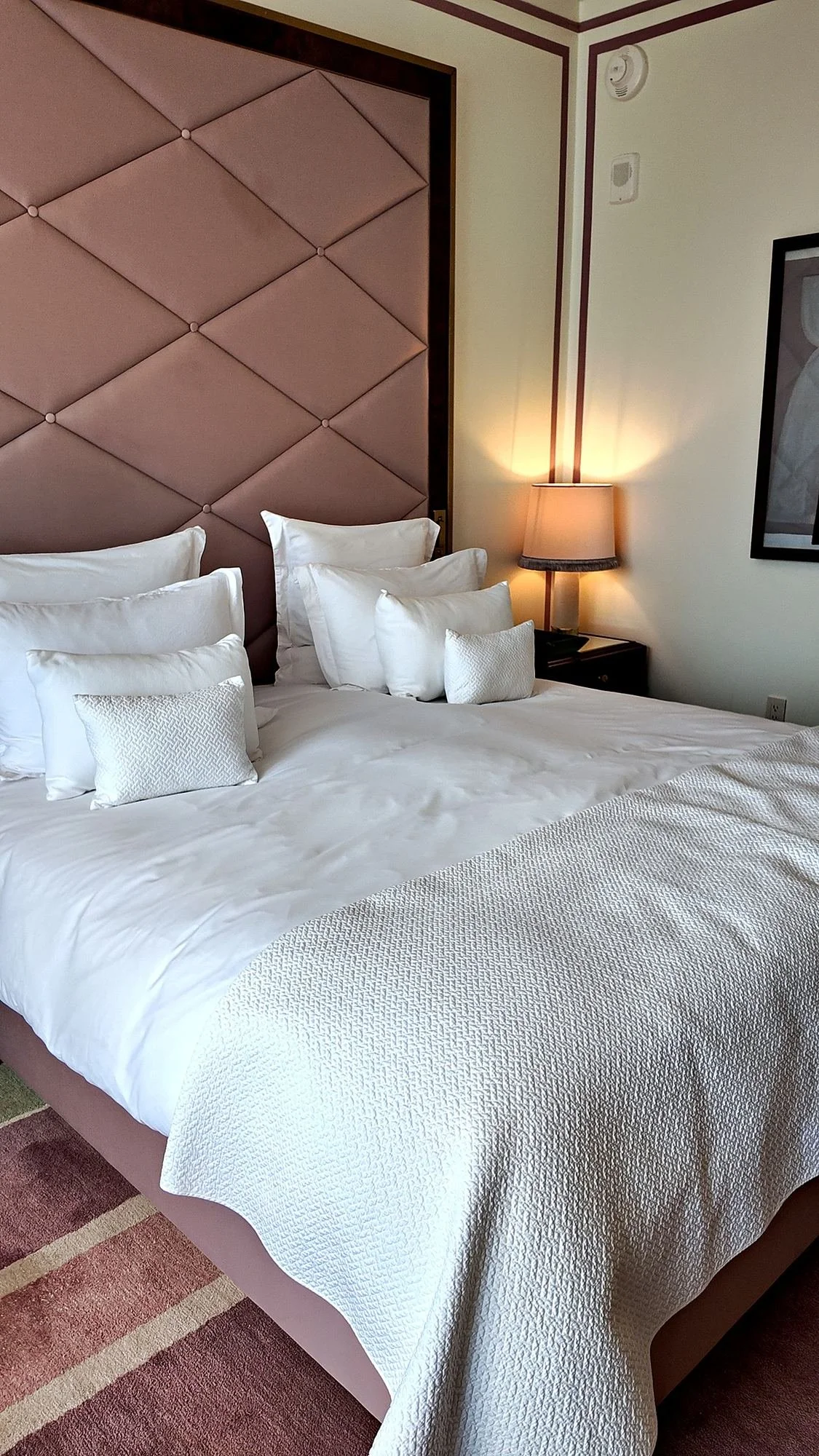 The bed in the Prestige room at Fouquet's New York, with white bedding and a tall quilted headboard.