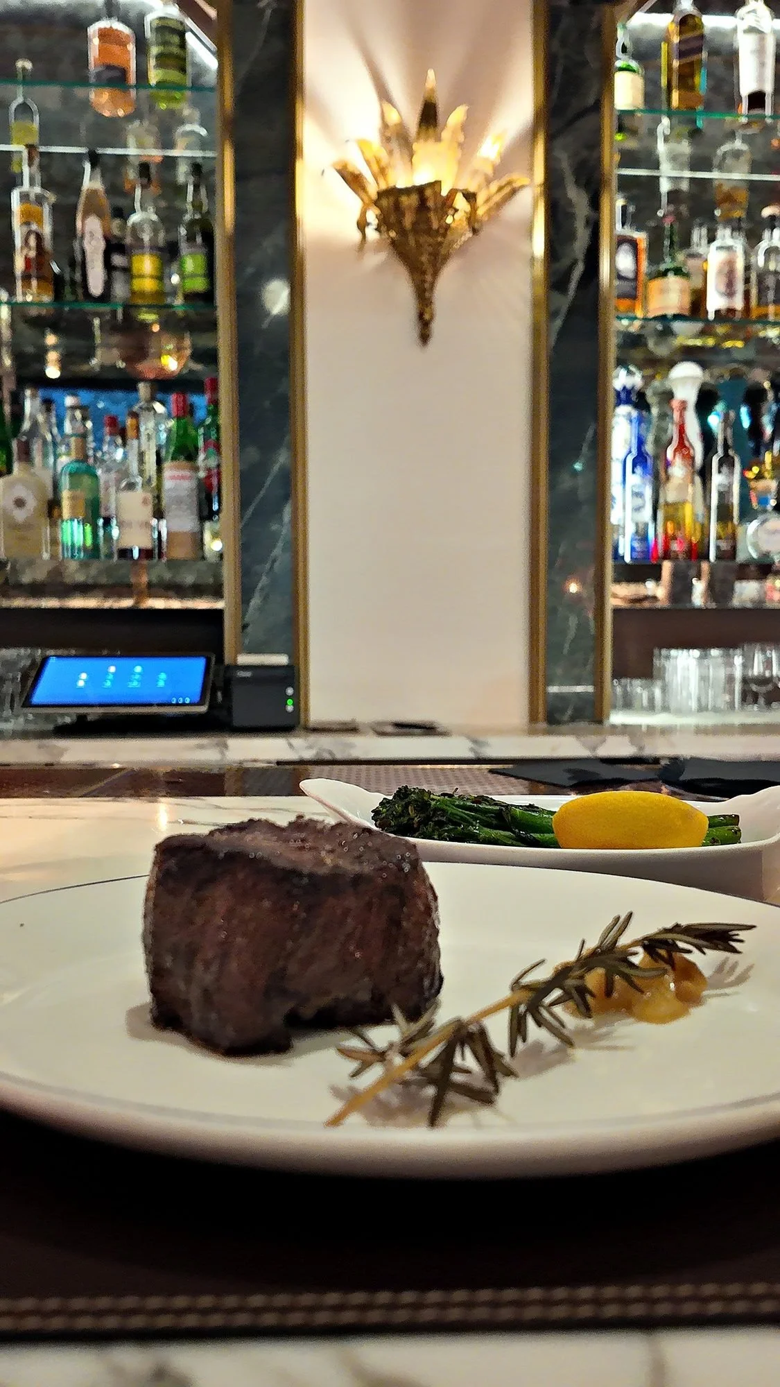 A filet mignon and grilled asparagus set for one at the bar at La Marchande, inside The Wall Street Hotel.