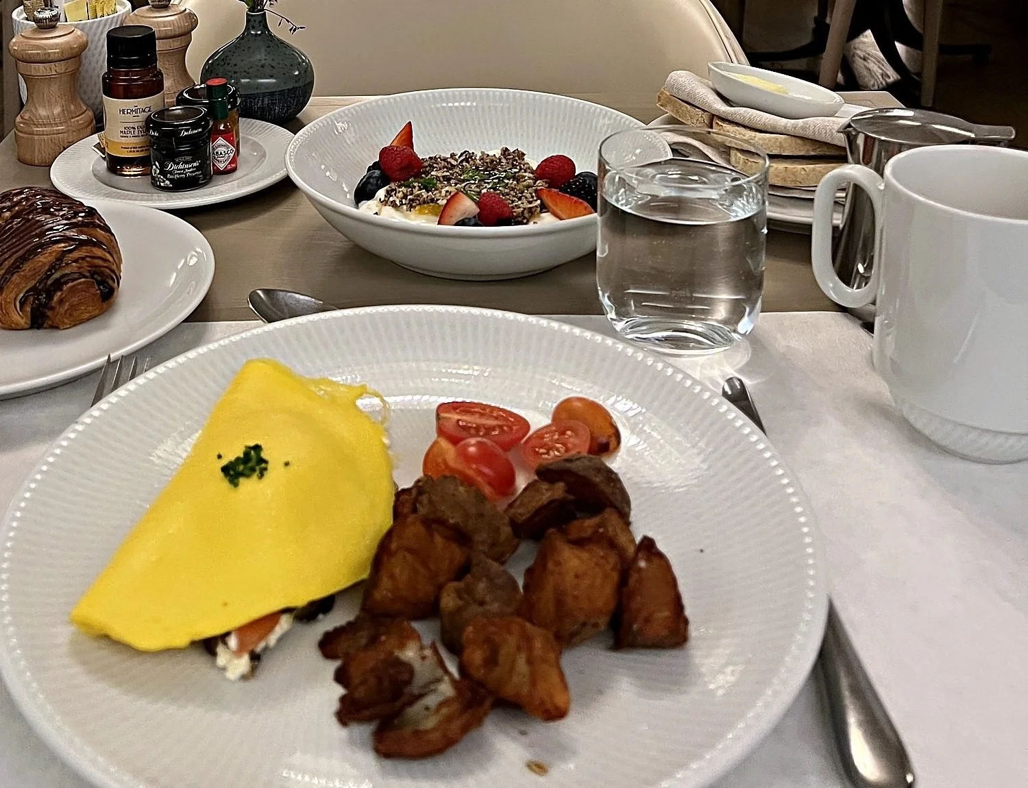 My brunch at Drusie & Darr, The Hermitage Hotel, Nashville: an omelet with potatoes and tomatoes, a chocolate croissant, yogurt with berries, water and coffee