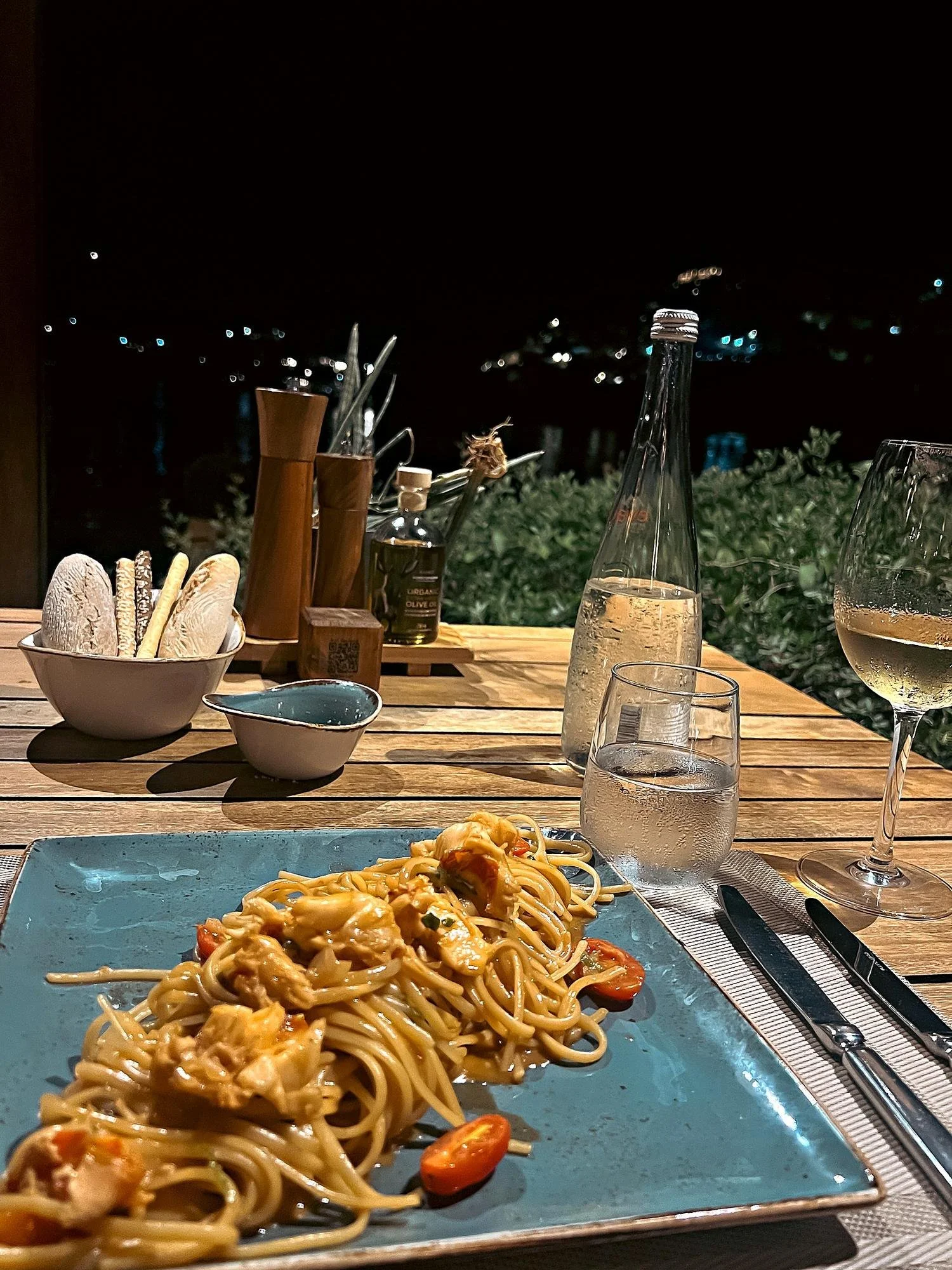 Lobster pasta and a glass of local white at Yali, Grecotel Corfu Imperial, Corfu, at night, with the lights of the yachts across the bay
