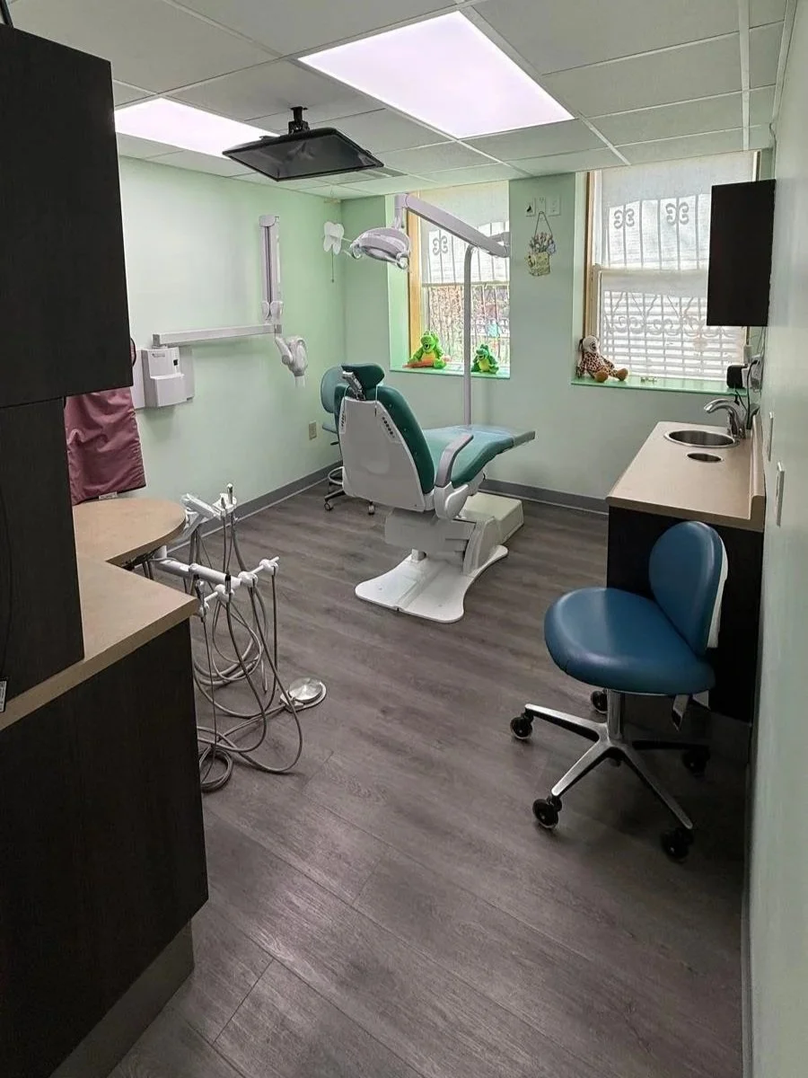 operatory: dental chair, clinician chair, 2 windows, partial view of desk, TV on ceiling for patient
