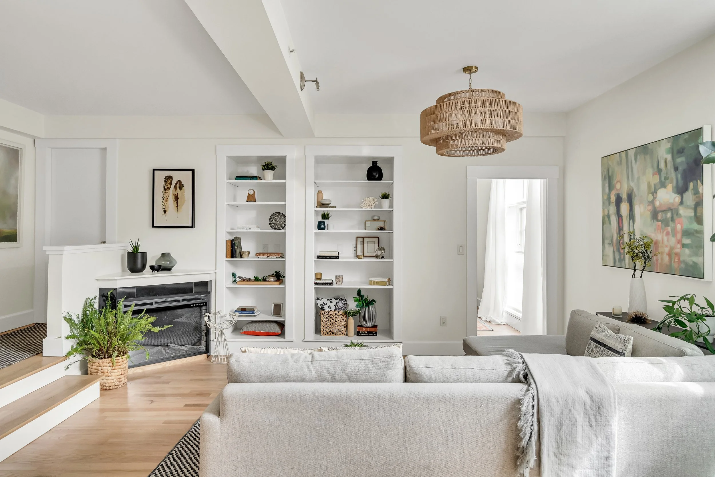 Painted yellow-toned wood into white, ran a new overhead light fixture, refinished floors, and added curtains to the space.
