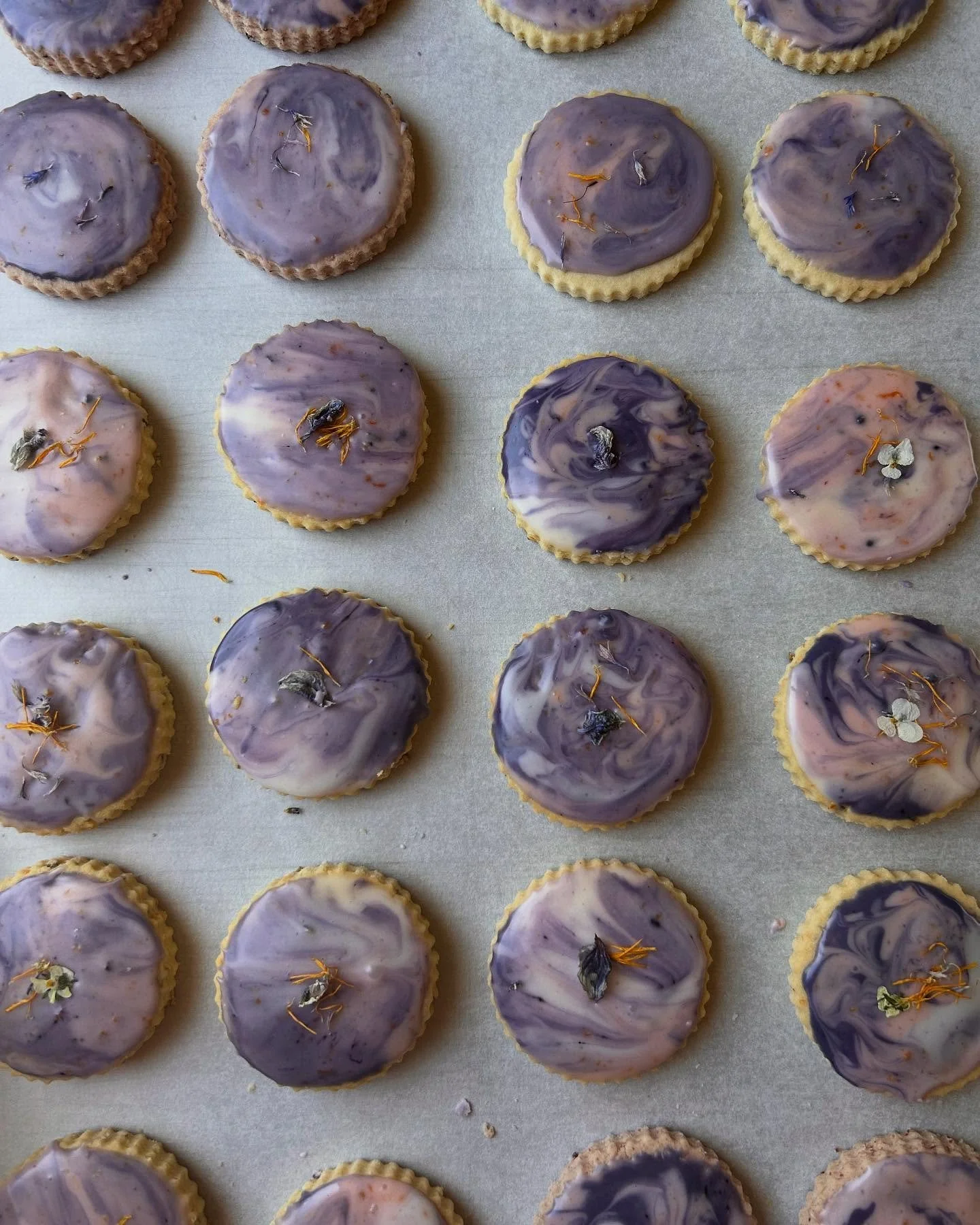 A flashback moment for these tie-dye shorties from Easter 🪩 these came as a variety box of lavender- orange, lemon-lime, &amp; strawberry-rosewater; all decorated with a blue butterfly pea flower glaze &amp; edible flowers 🦋🌼