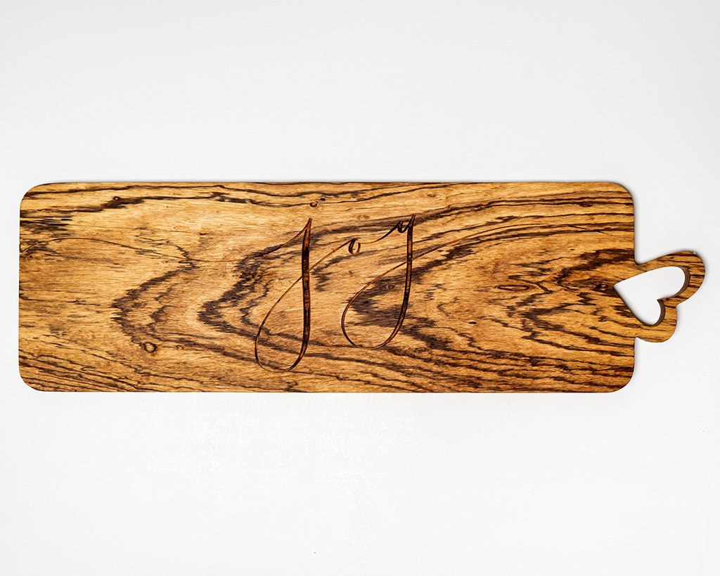 Joy-themed charcuterie board with beautiful wood grain and heart-shaped handle.