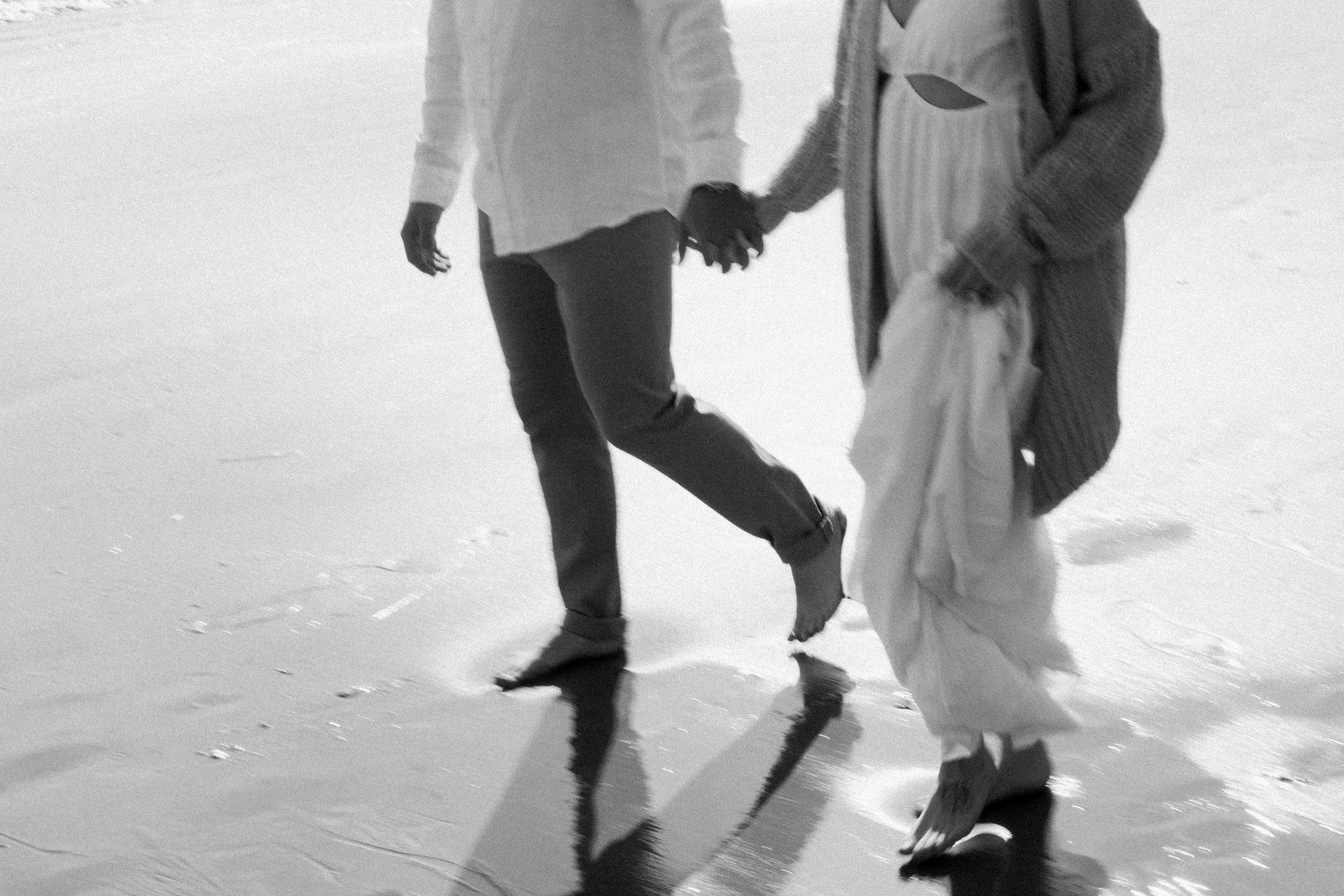 People holding hands and walking by the ocean in California, Laguna Beach.