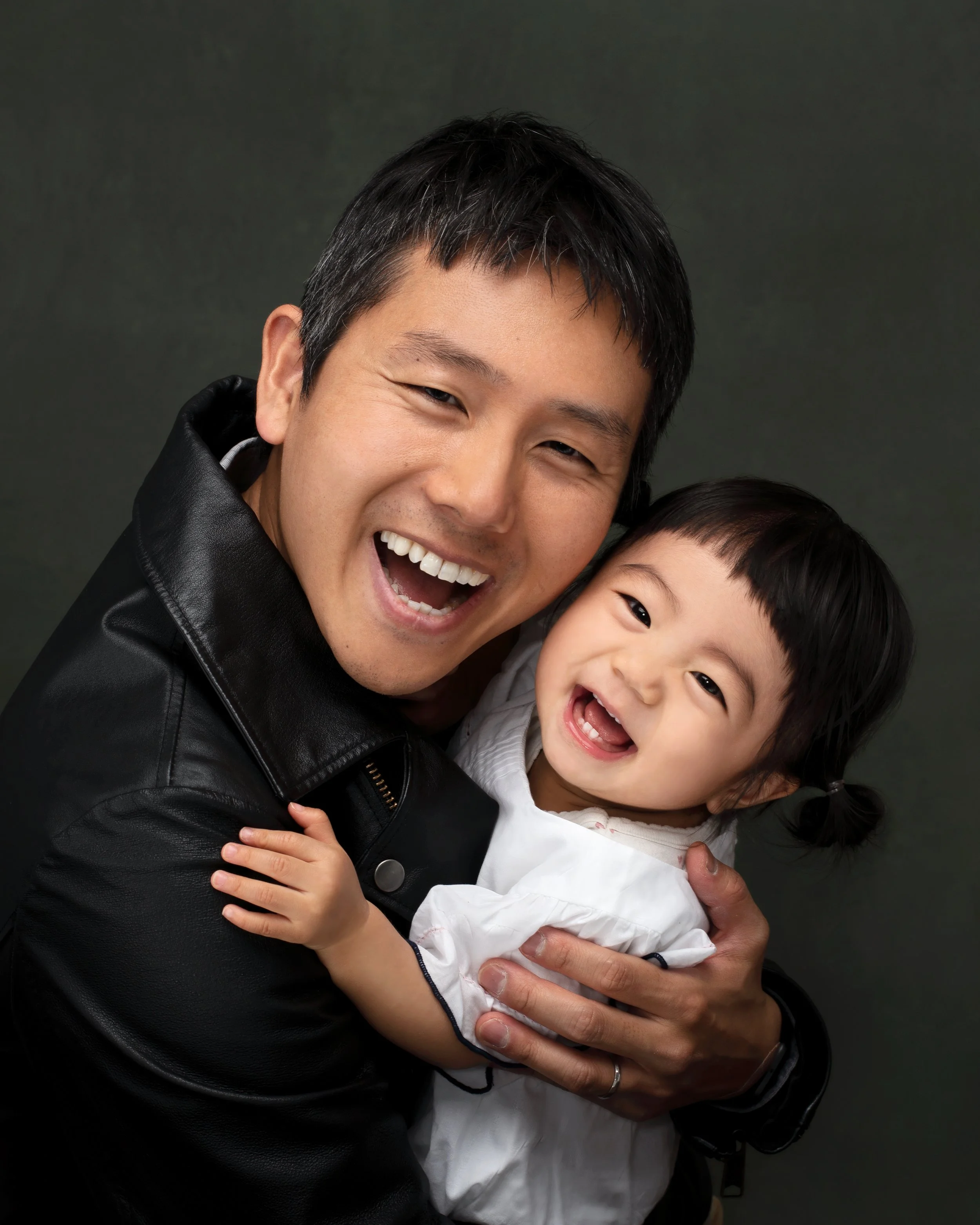 A man and a young girl smiling and hugging each other.