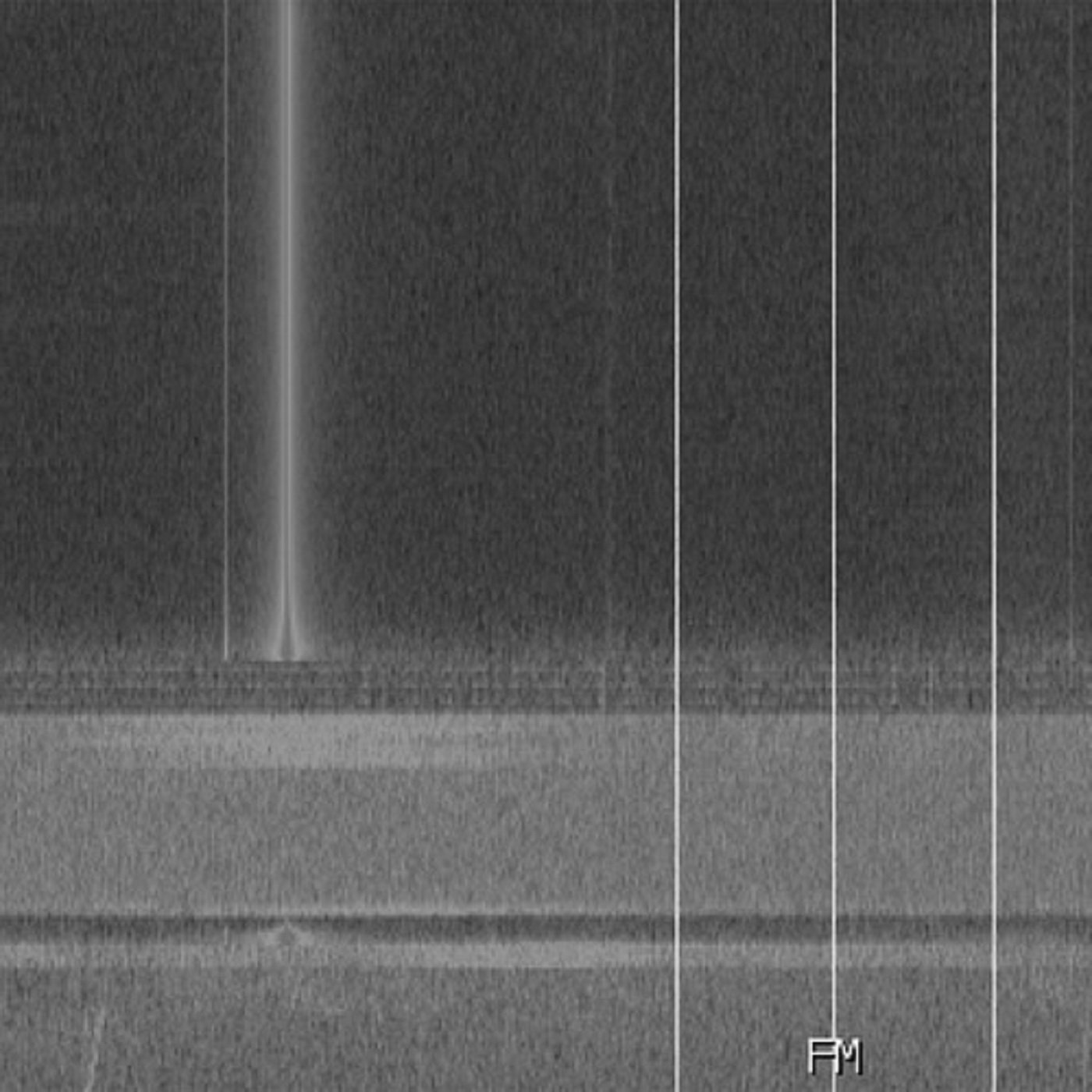 Close-up image of a metallic radio tuner with a needle pointing near the FM band.