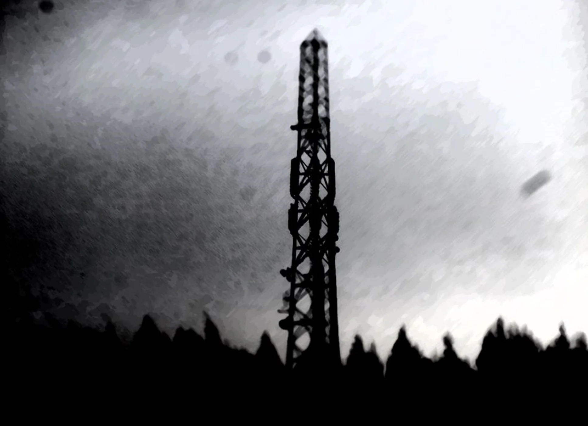 The silhouette of a tall radio tower against a dark, stormy sky with trees at the base.