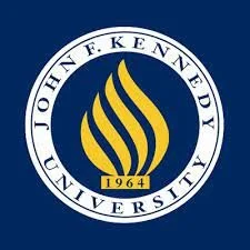 Logo of John F. Kennedy University featuring a blue circular background, gold flame-like symbol, and the university name with the year 1964.