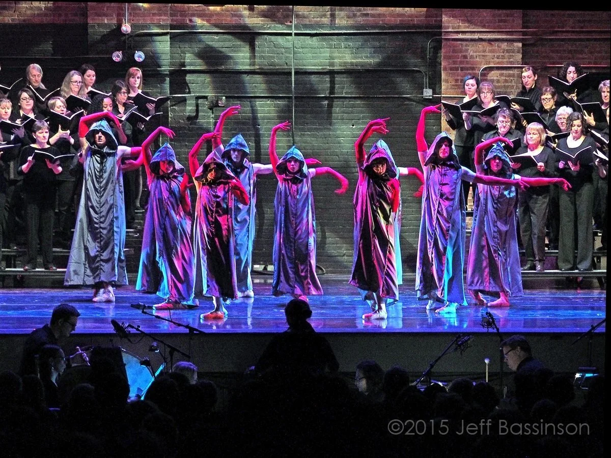 Carmen Burana at the Missouri Theatre - 8 dancers in grey dresses and hoods with long red gloves lit in multicolored and textured light.
