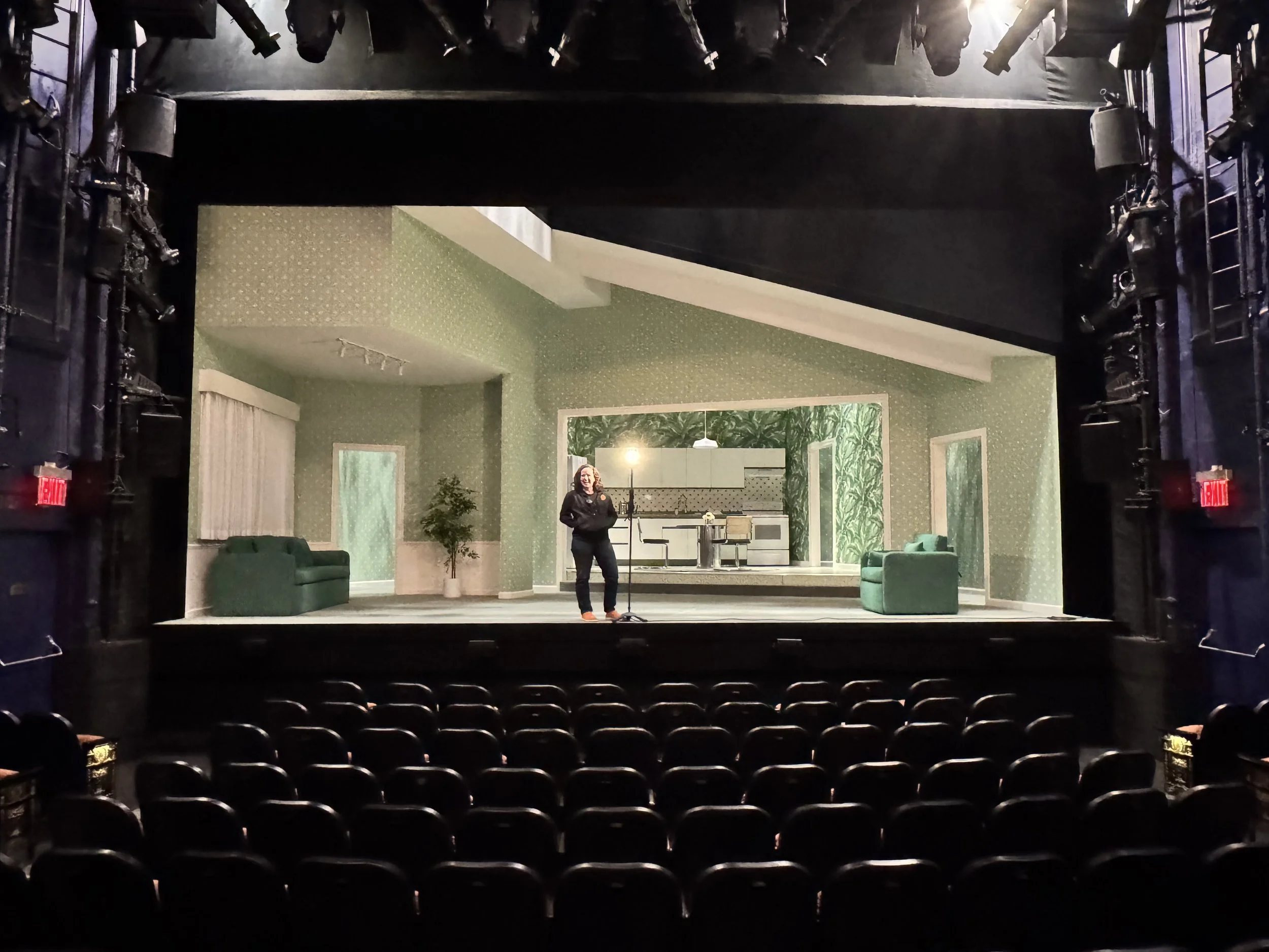 Savannah standing on the Hayes stage next to the ghost light with Marjorie Prime's set in the background.