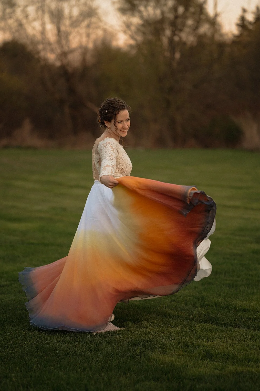 Savannah in her wedding dress which was tie dyed at the bottom twirling around in a feild