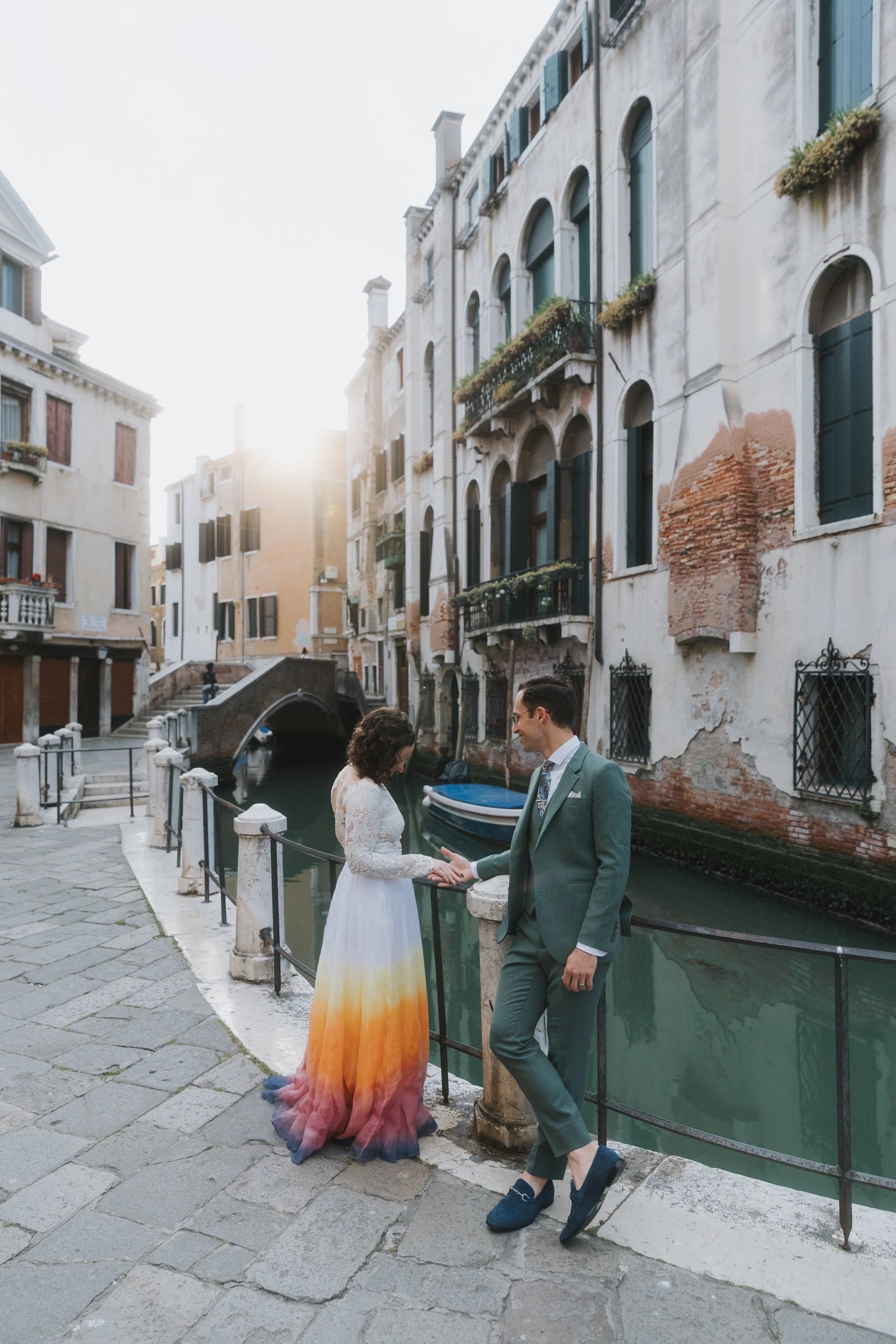 Venice, Italy honeymoon photos of Will and Savannah next to the canal in their wedding attire.