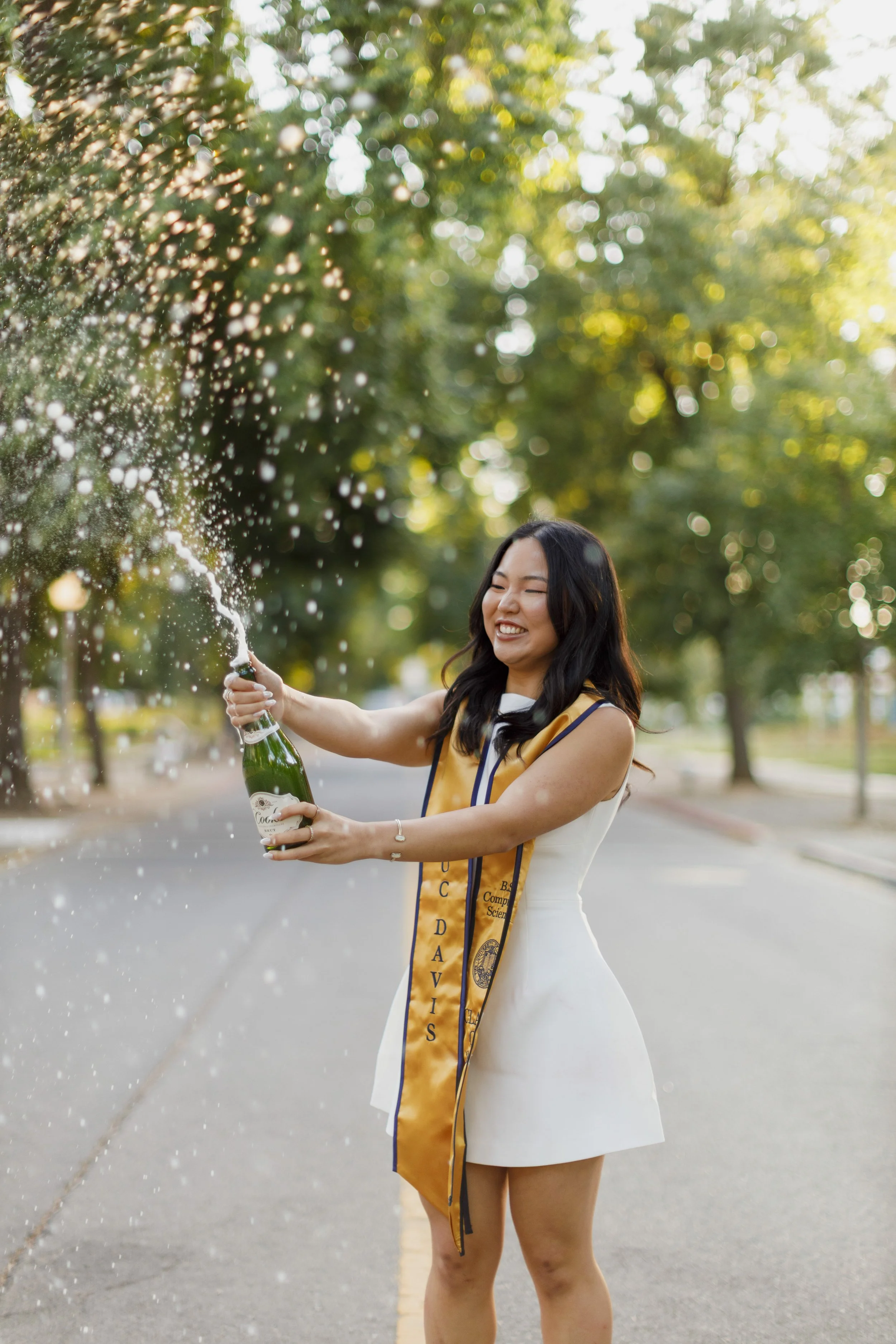UC Davis graduation photo with champagne popping