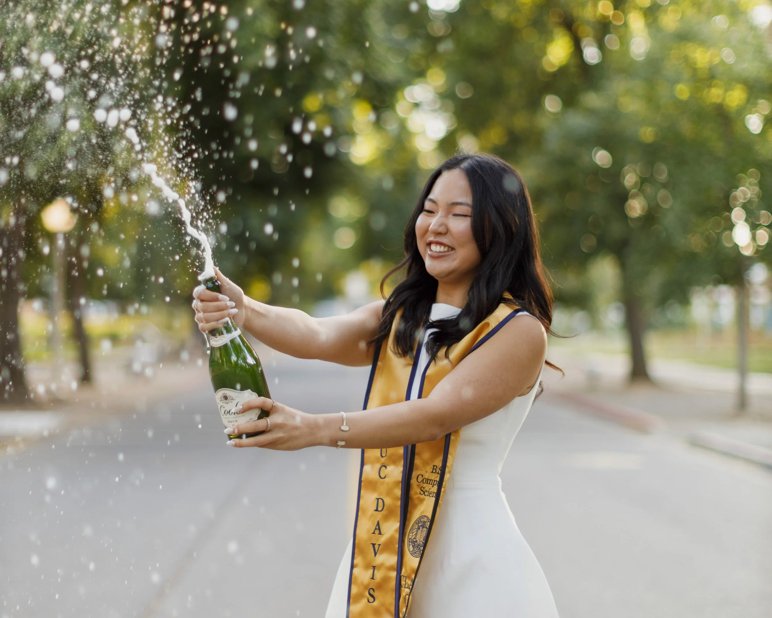 Solo champagne popping photo under a tree campus at UC Davis.