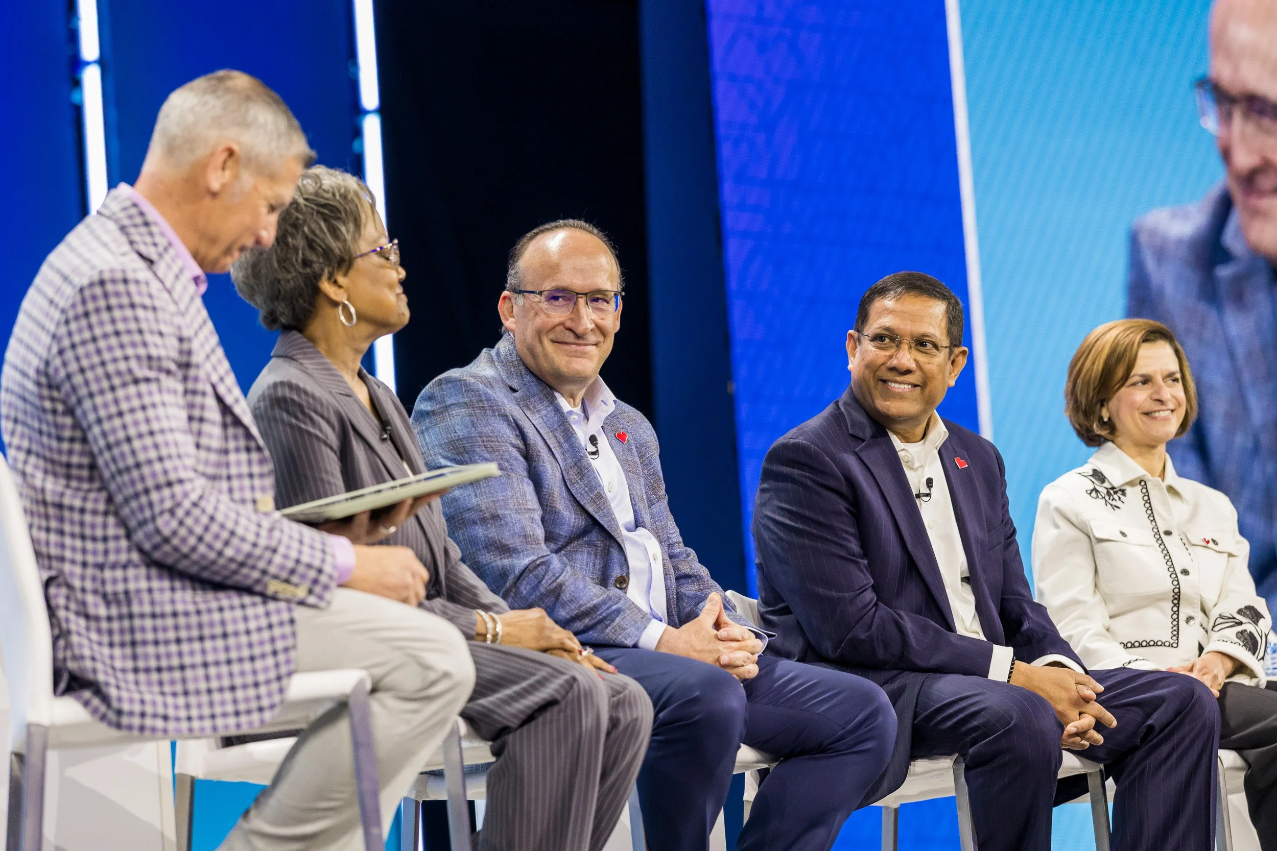 close-up-of-Panel-of-smiling-speakers-on-stage.jpg