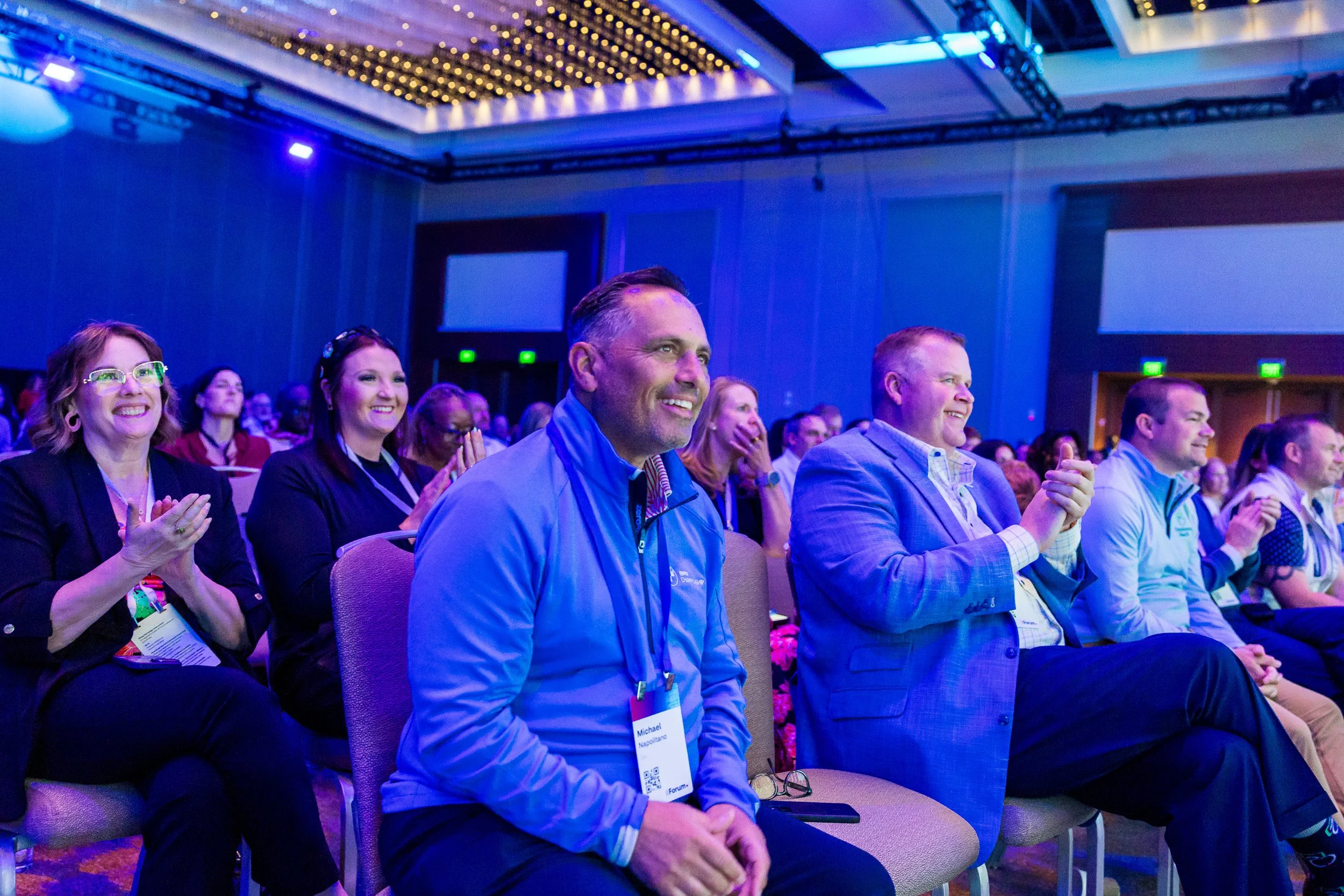 close-up-of-audience-reacting-to-keynote-speaker-with-applause-and-smiles.jpg