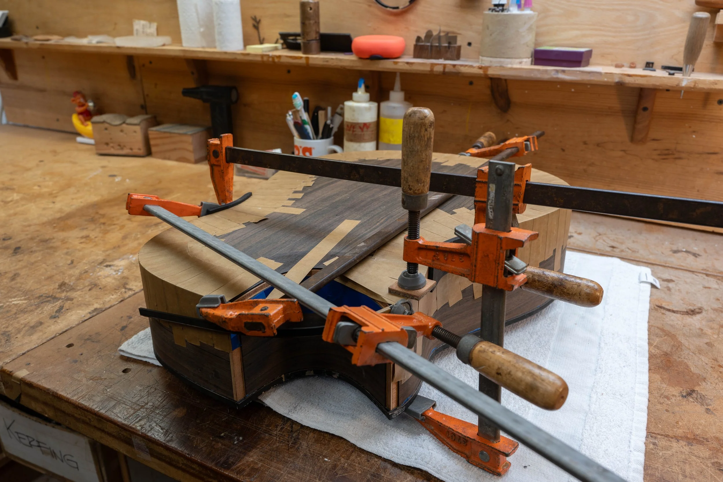 Glueing the binding with tape on a Silverman guitar