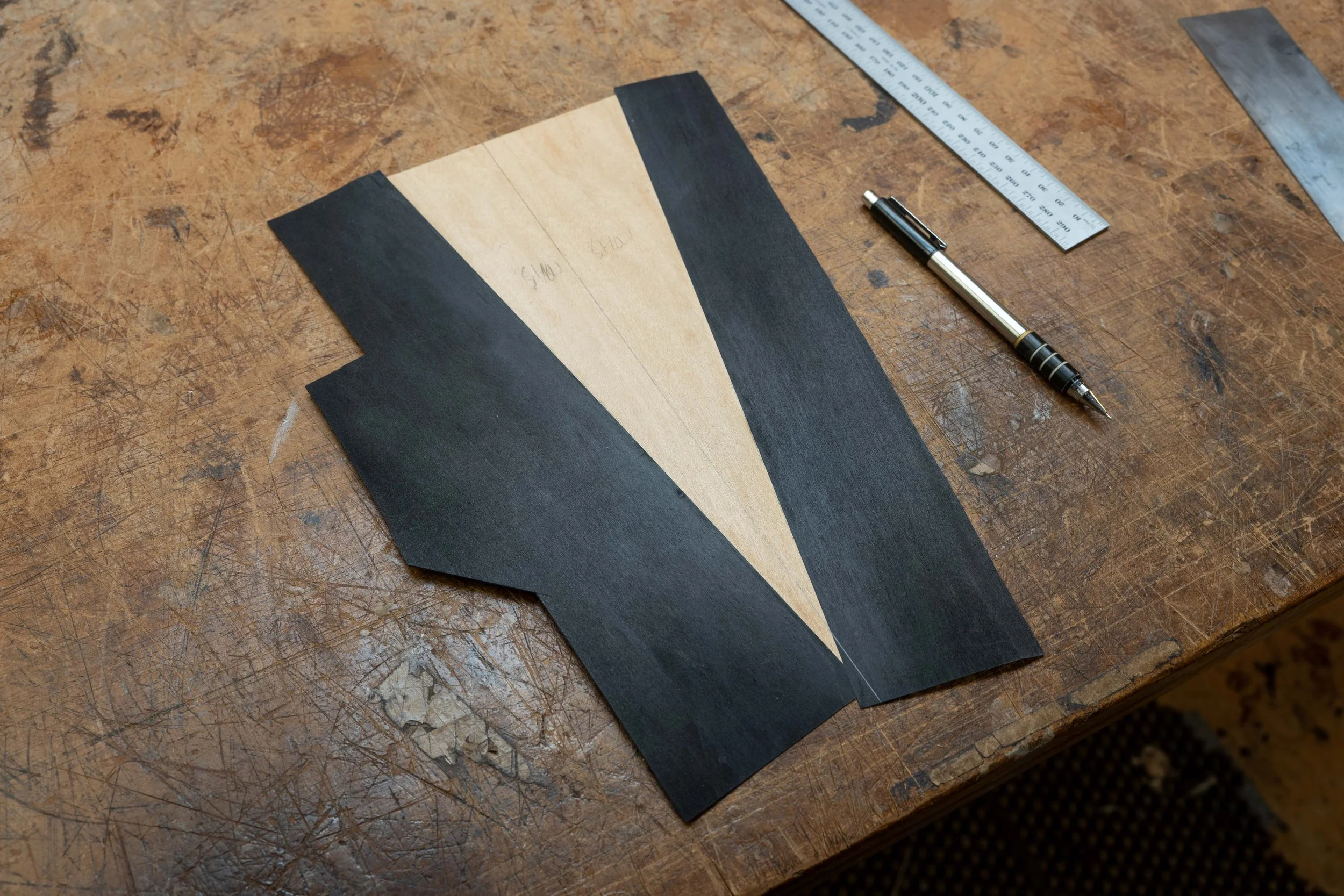After thicknessing the headstock, I added the front and back veneers. For this design I wanted to have white veneer revealed only in the centre split part, and not on the edges. To create this effect, for that layer of veneer I glued up some black an