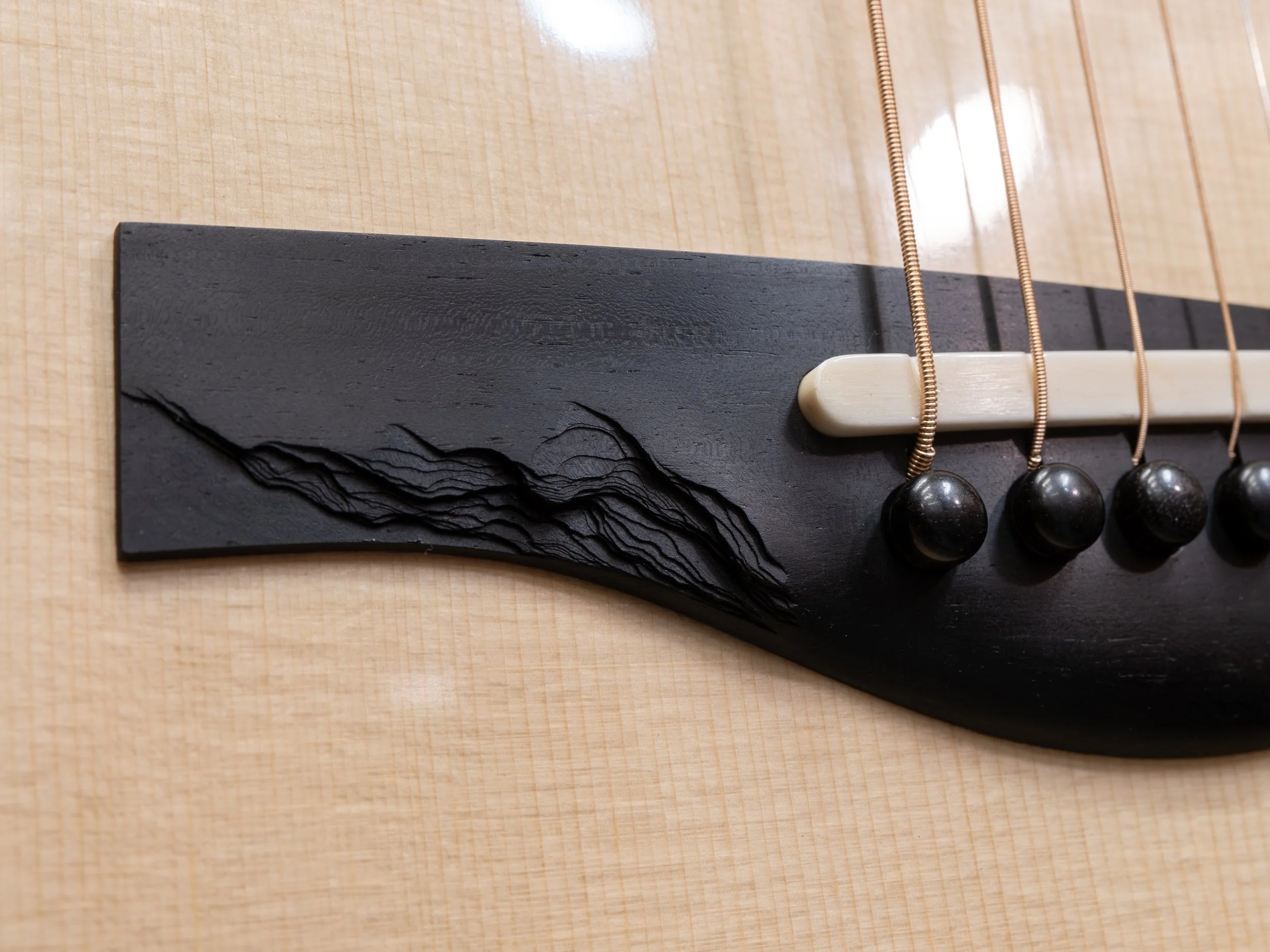Stepped rock slate texture on Silverman guitar bridge.
