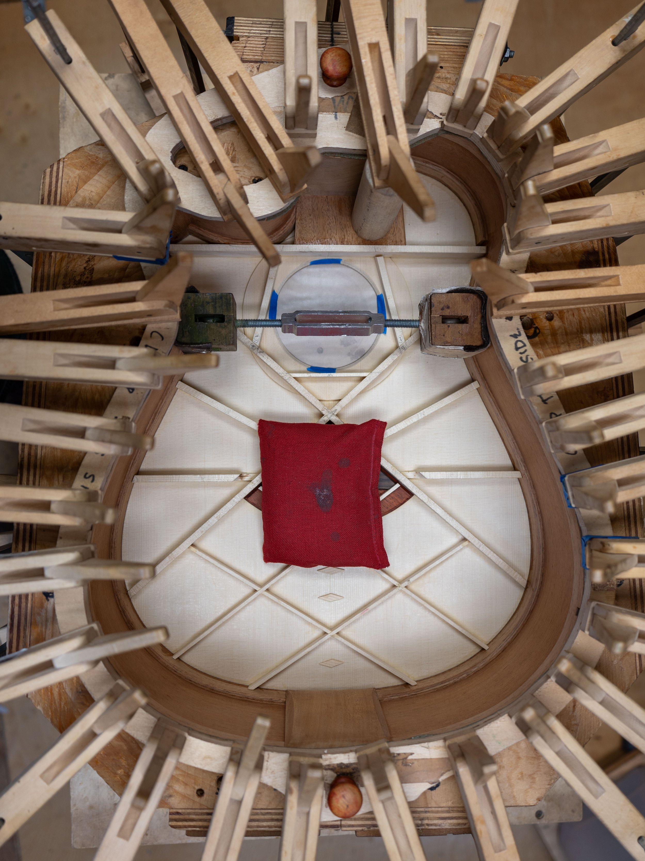 Silverman Guitars clamping the rim to the top, showing the braces