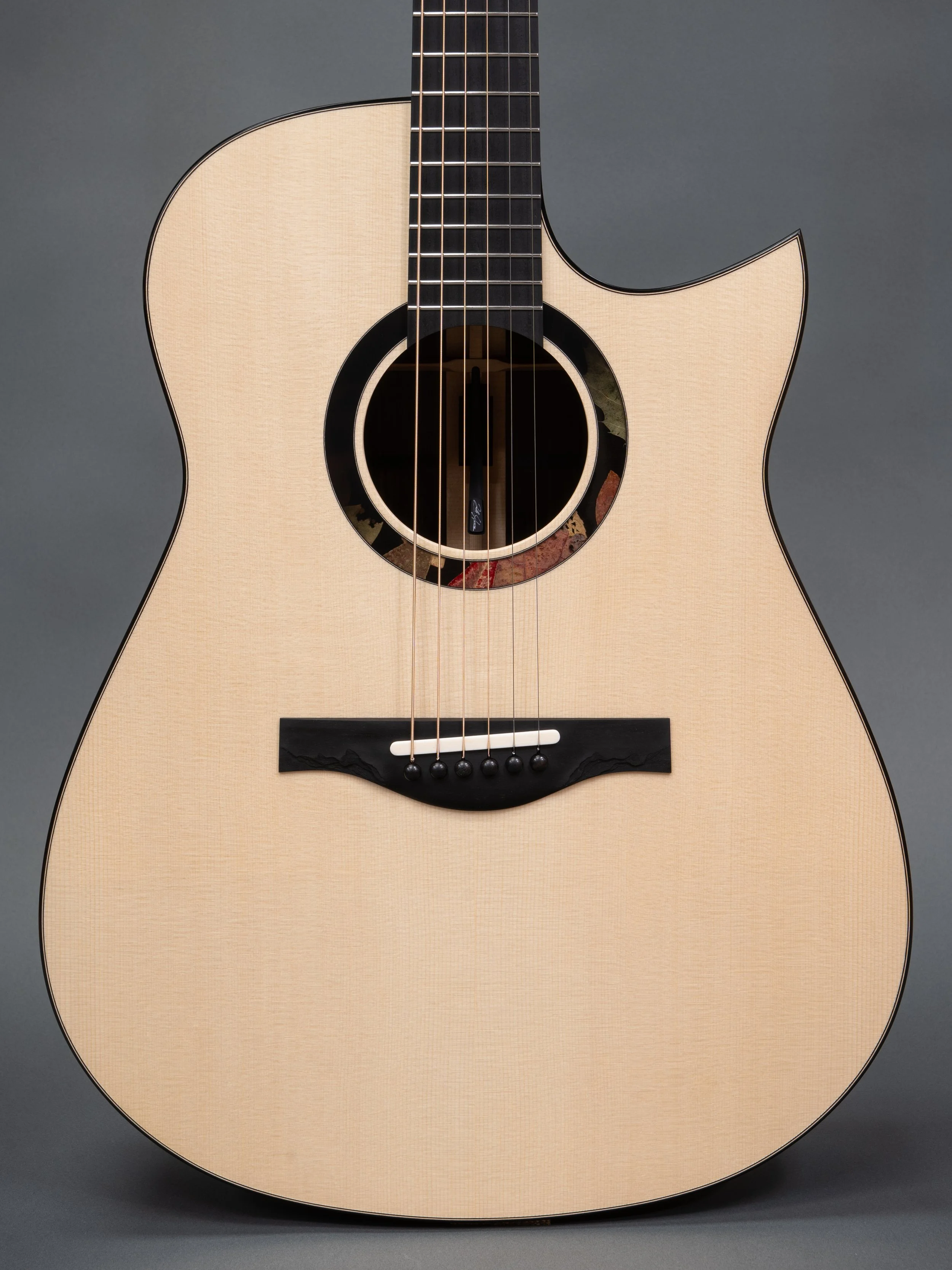 Silverman guitar with leaves in epoxy resin rosette, and rock/bark texture bridge.