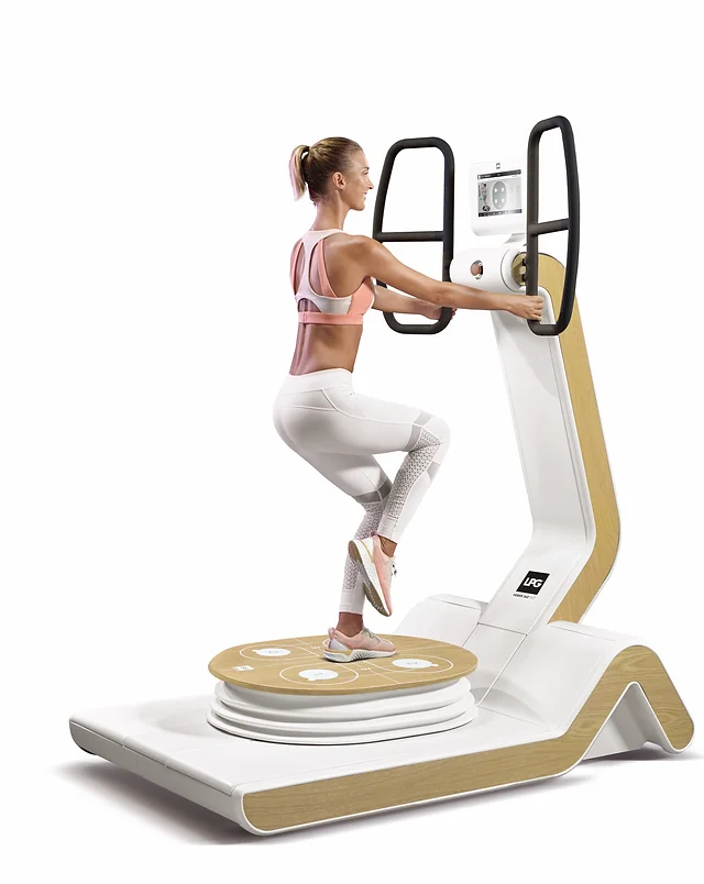 Woman exercising on a fitness machine with a circular platform and handlebars