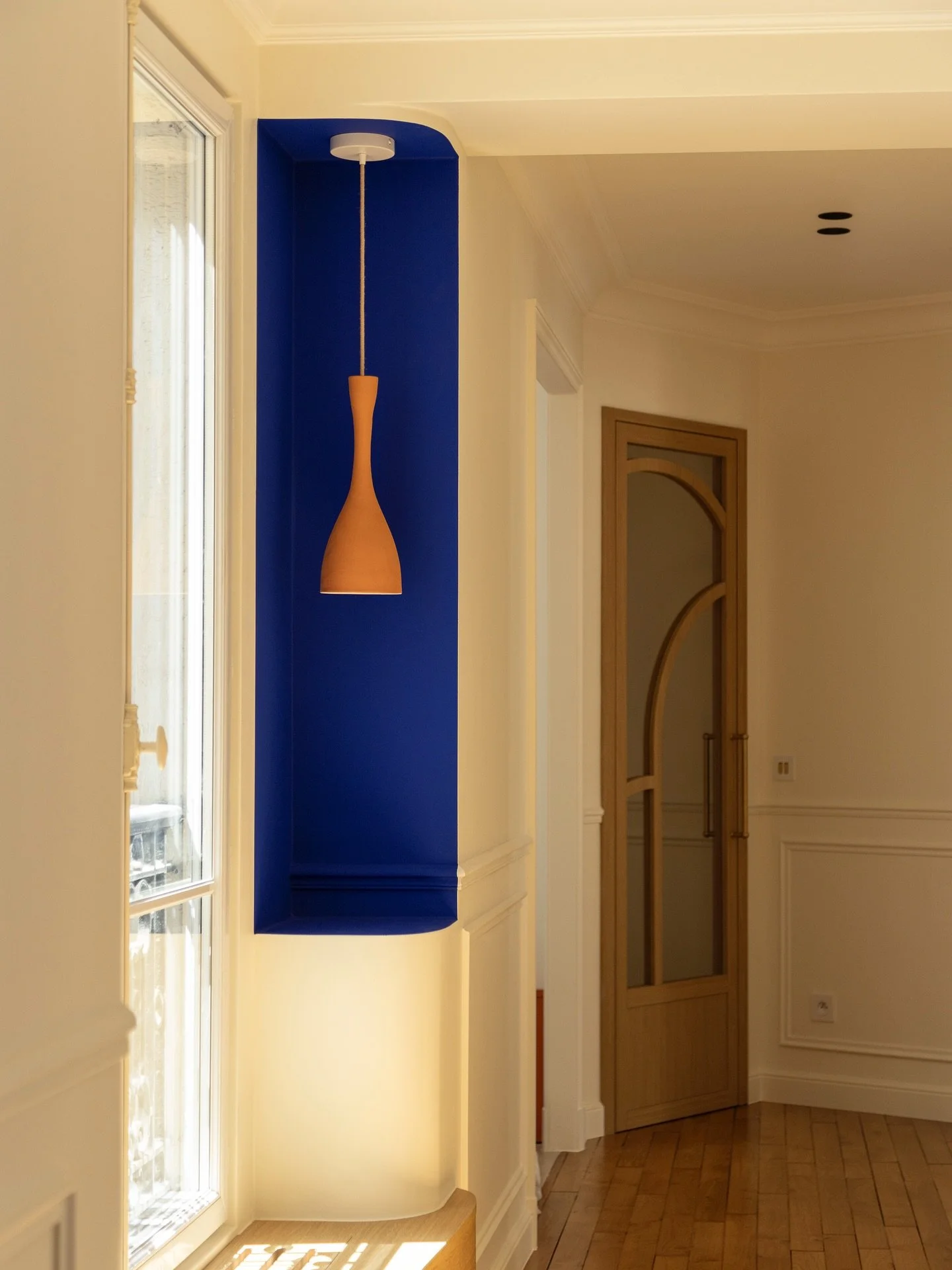 Dans l&rsquo;entr&eacute;e de l&rsquo;appartement L&eacute;on Cognet, les d&eacute;tails font tout : niche murale en bleu profond, applique terracotta, porte cintr&eacute;e sur-mesure.
Projet imagin&eacute; par @cactusarchitecture r&eacute;alis&eacut
