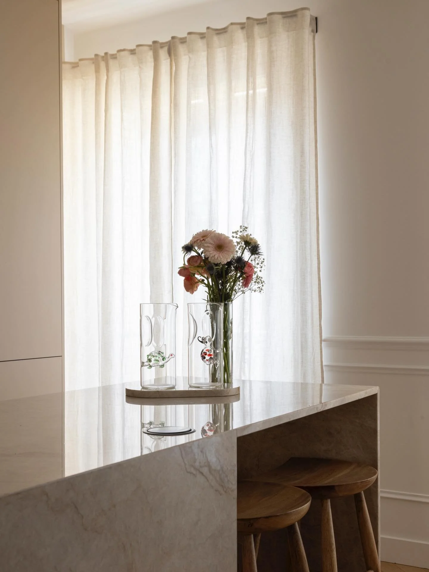 Dans cet appartement &agrave; Neuilly, @Sarahbenhamou.interior imagine une cuisine aux tons doux, entre beige et pierre naturelle. Aurelia R&eacute;novation a r&eacute;alis&eacute; les agencements sur-mesure, du plan de travail &agrave; la menuiserie