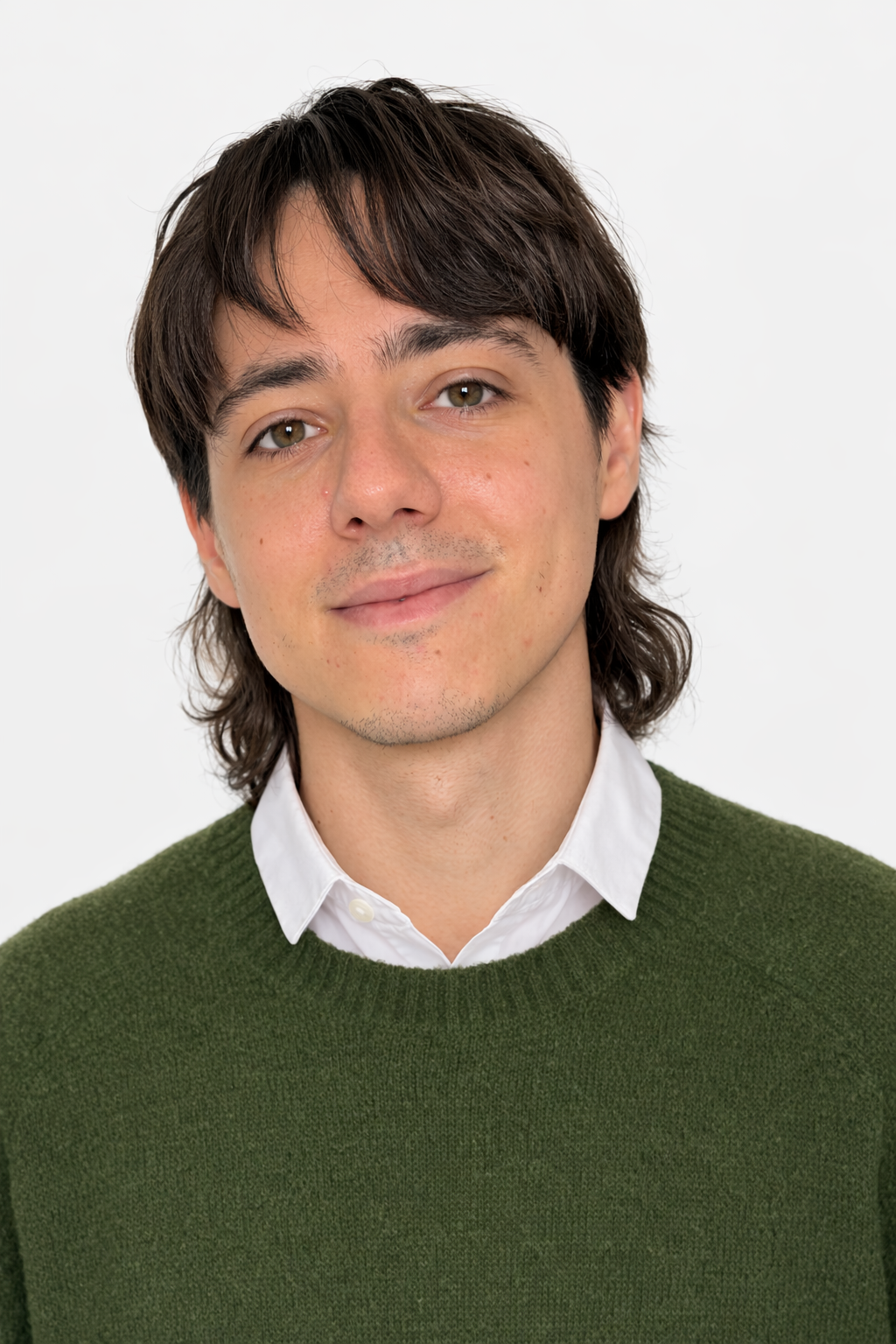 Ritratto dello psicologo Lorenzo Buggio. Uomo con capelli castani, indossa una camicia bianca e un maglione verde, sfondo bianco.