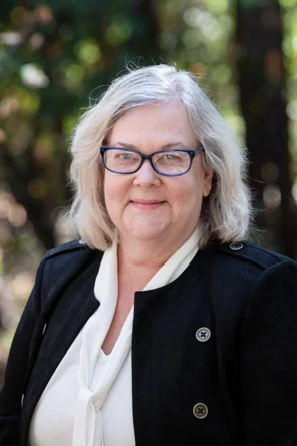 Kim Jinnett wearing a white blouse and black jacket