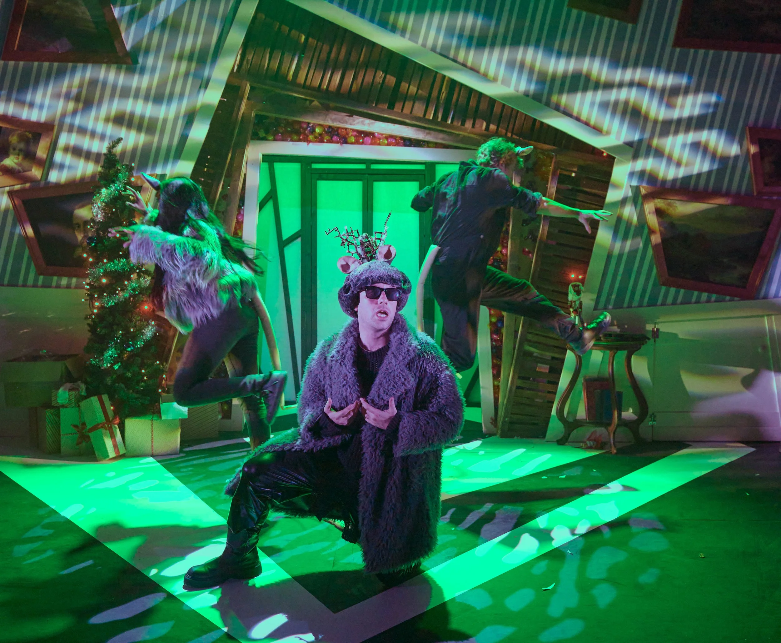 An actor in a mouse costume sings a song with green and white lighting