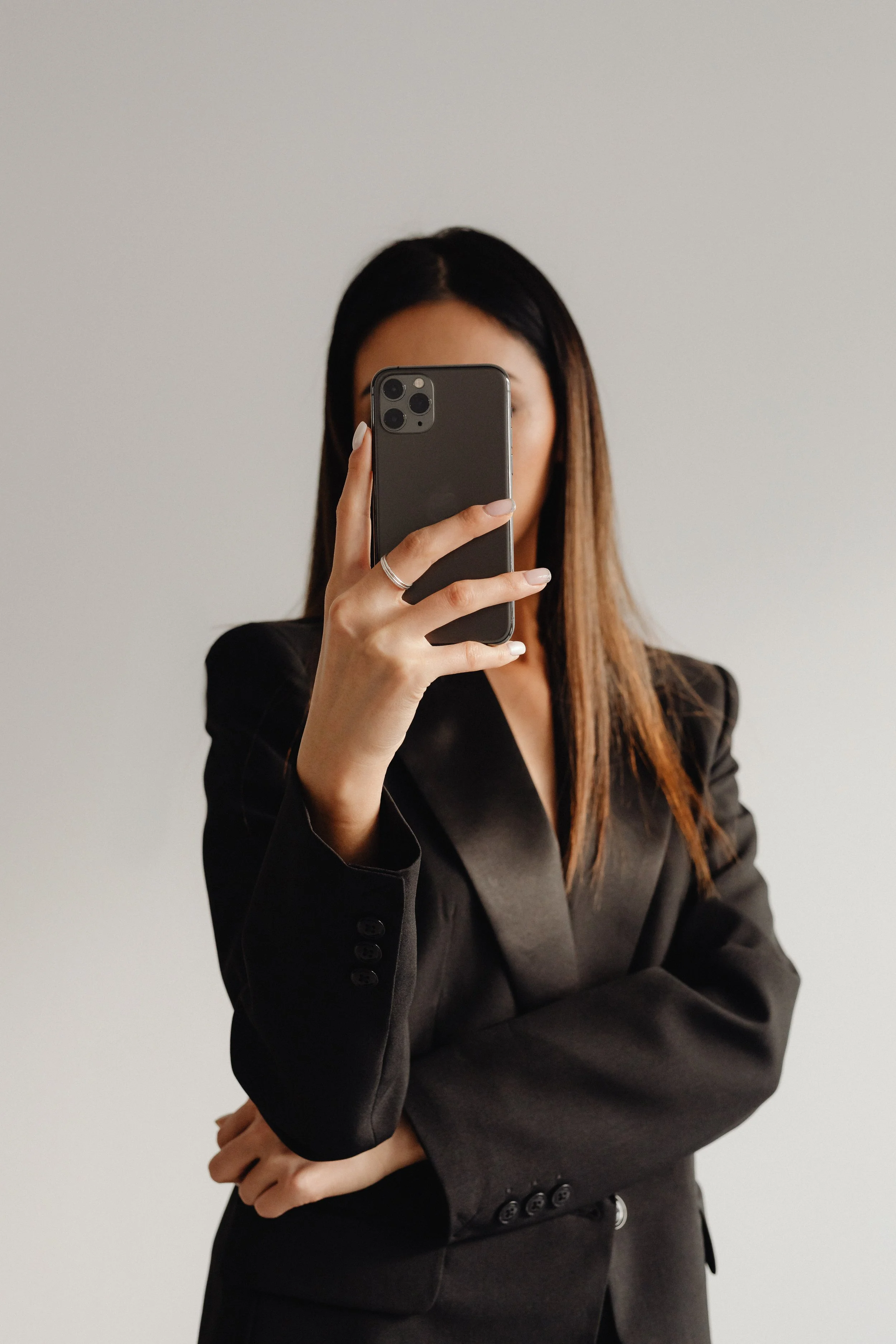 kaboompics_dark-classy-aesthetic-fashion-beautiful-asian-female-entrepreneur-in-black-suit-technology-and-devices-iphone-laptop-airpods-30095.jpg