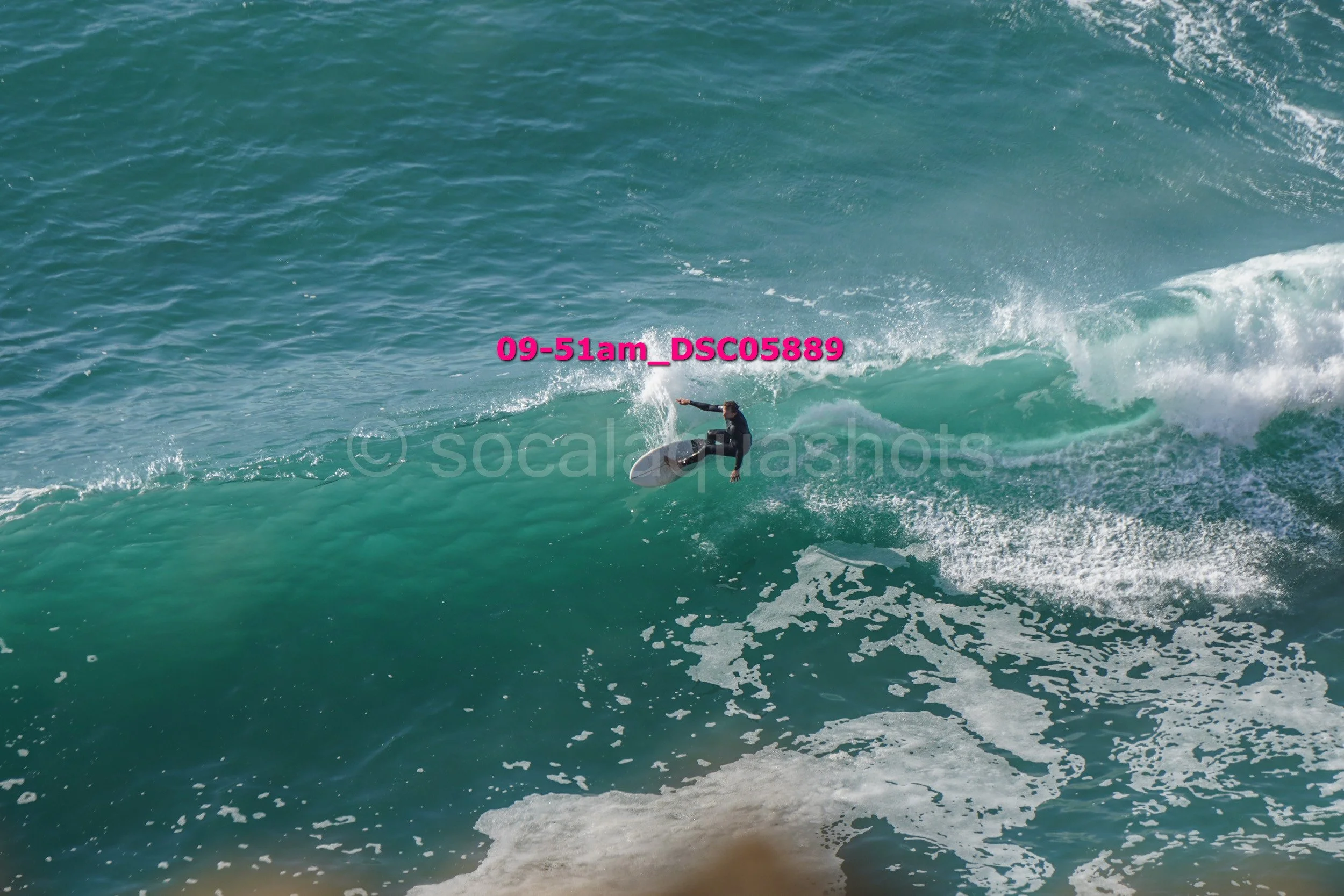 A person surfing on a large ocean wave during daylight hours.