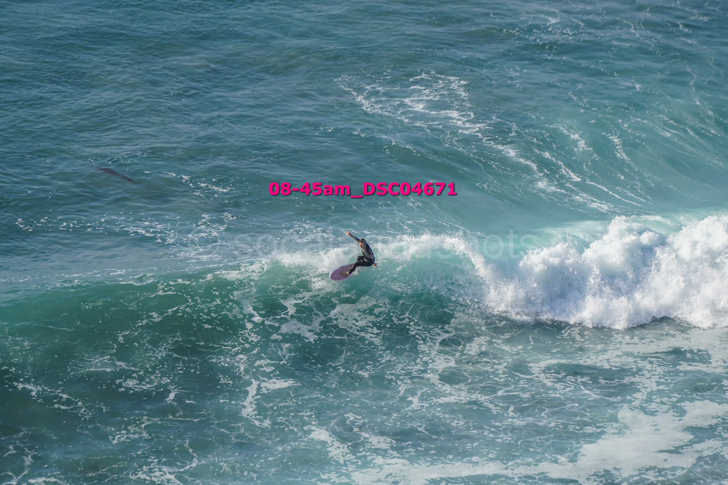 A person surfing on a wave in the ocean.