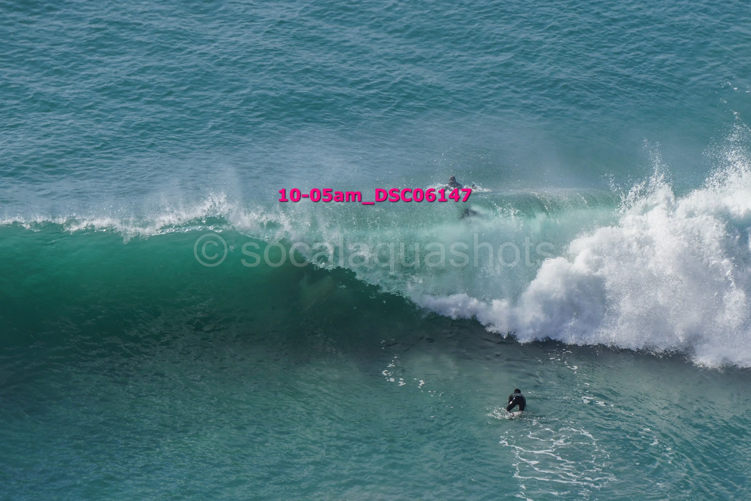 Surfer riding a large crashing wave in the ocean.